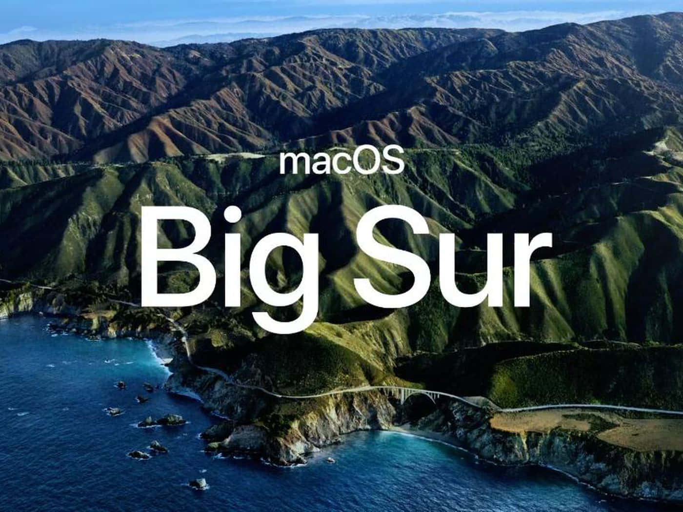 macOS Big Sur 動態桌布 桌布 壁紙 — 崎嶇的綠色山脈與深藍色海洋交匯的鳥瞰圖，蜿蜒的海岸道路和「macOS Big Sur」文字疊加。