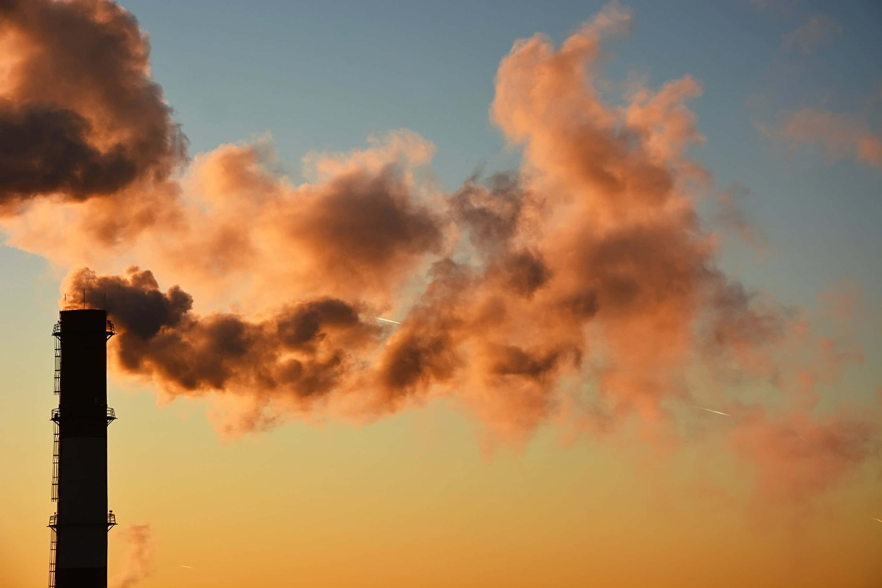 Pollution 桌布 壁紙 — 工廠煙囪在溫暖的日落天空下排放出濃厚的橙色煙霧。