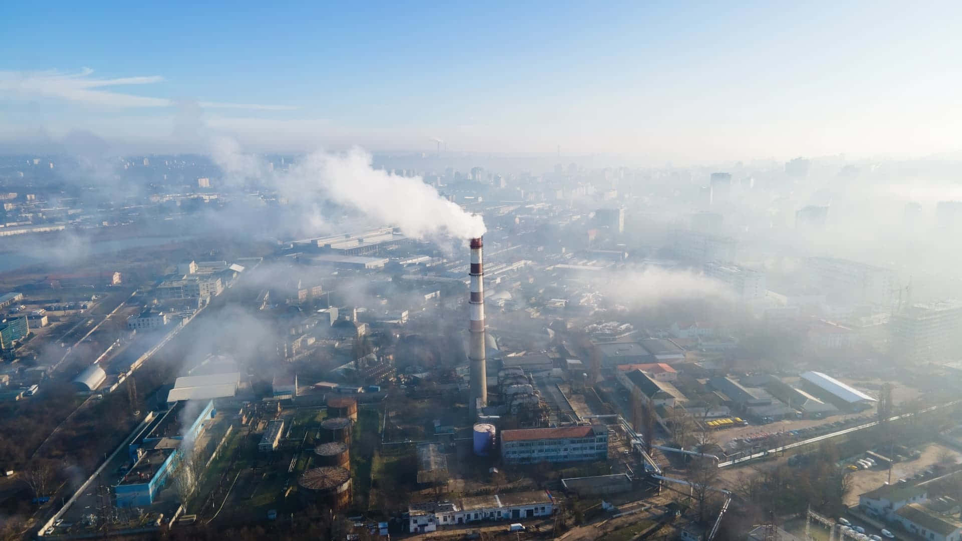 Pollution 桌布 壁紙 — 工業區的鳥瞰圖，煙囪冒出的濃厚白煙飄向城市上空朦朧的天空。