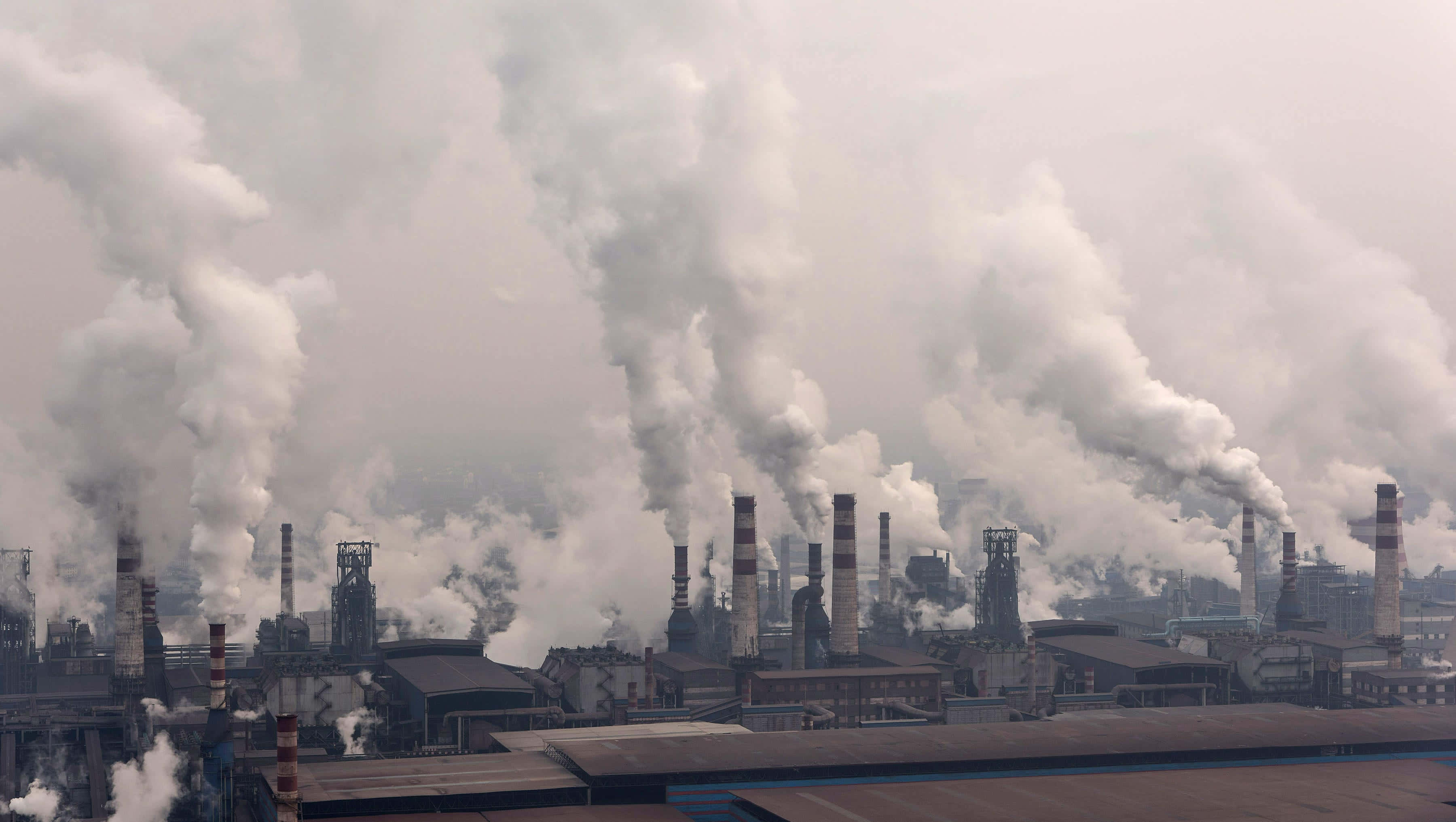 Pollution 桌布 壁紙 — 工業綜合體，眾多煙囪向灰濛濛的天空排放濃厚的白色煙霧。