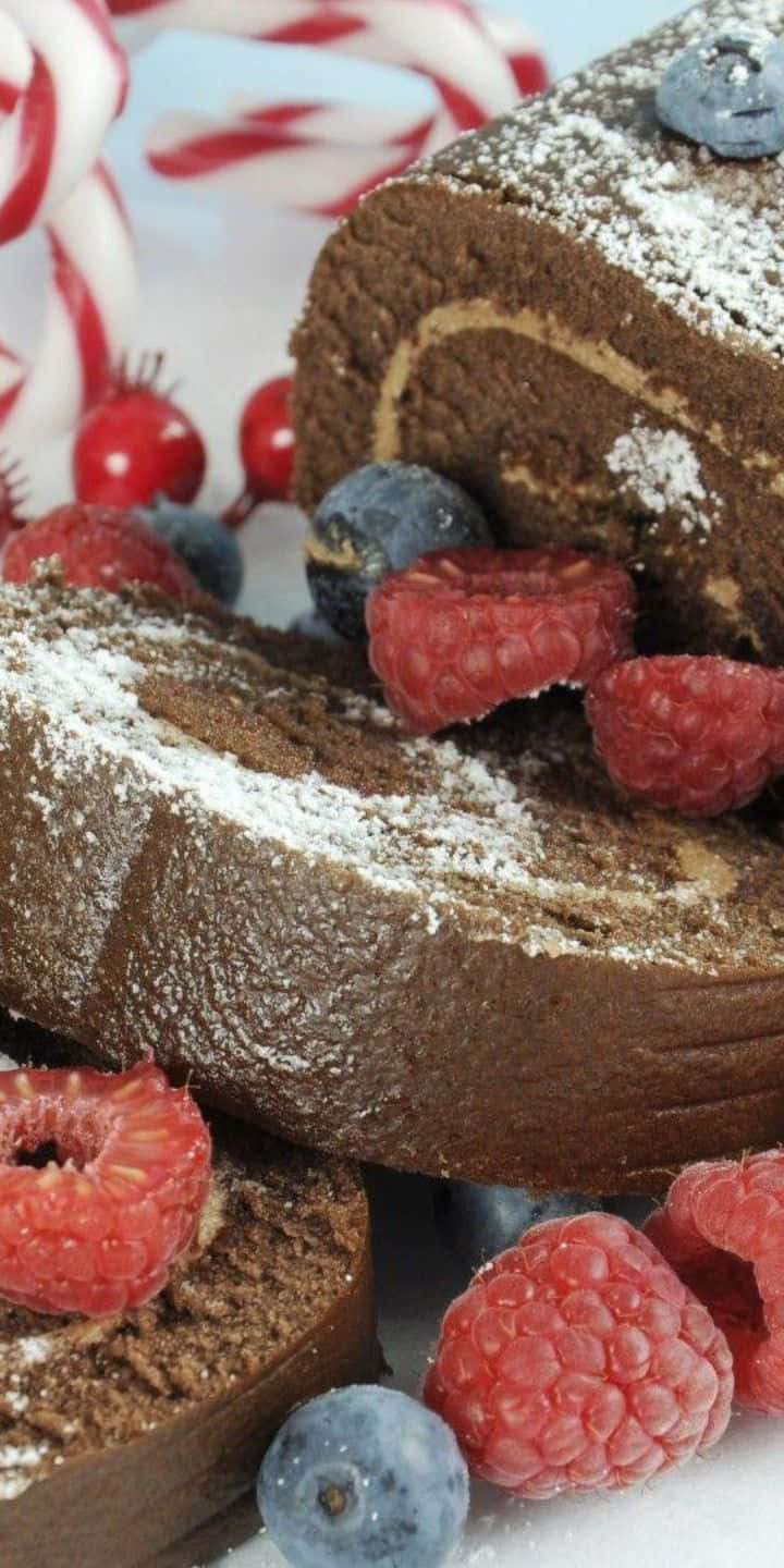 Pastry 桌布 壁紙 — 巧克力卷蛋糕的特寫，撒上糖粉，並以新鮮覆盆子和藍莓點綴。