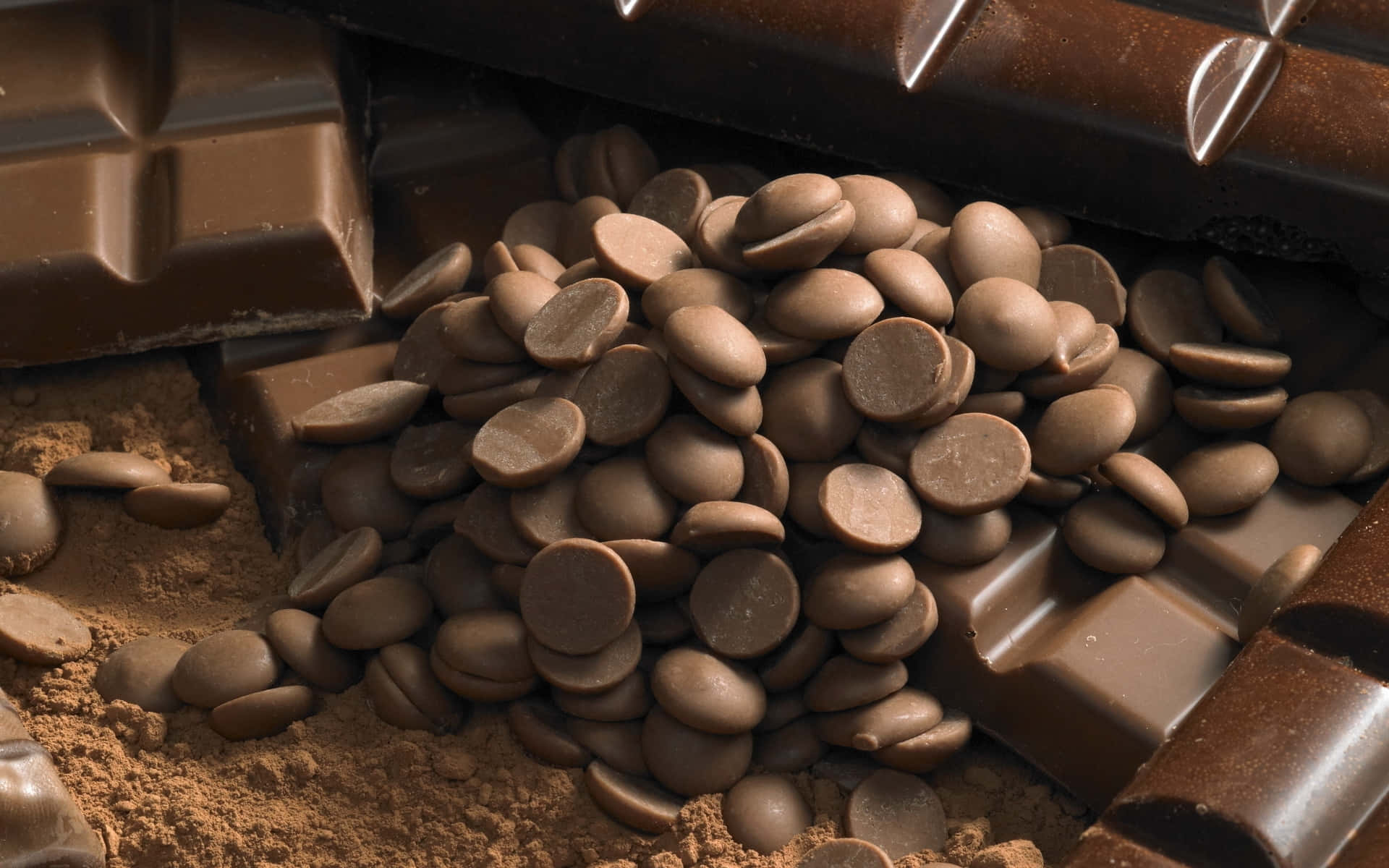 Brown Chocolate 桌布 壁紙 — 巧克力碎粒光澤特寫，堆放在破碎巧克力條和可可粉旁邊。