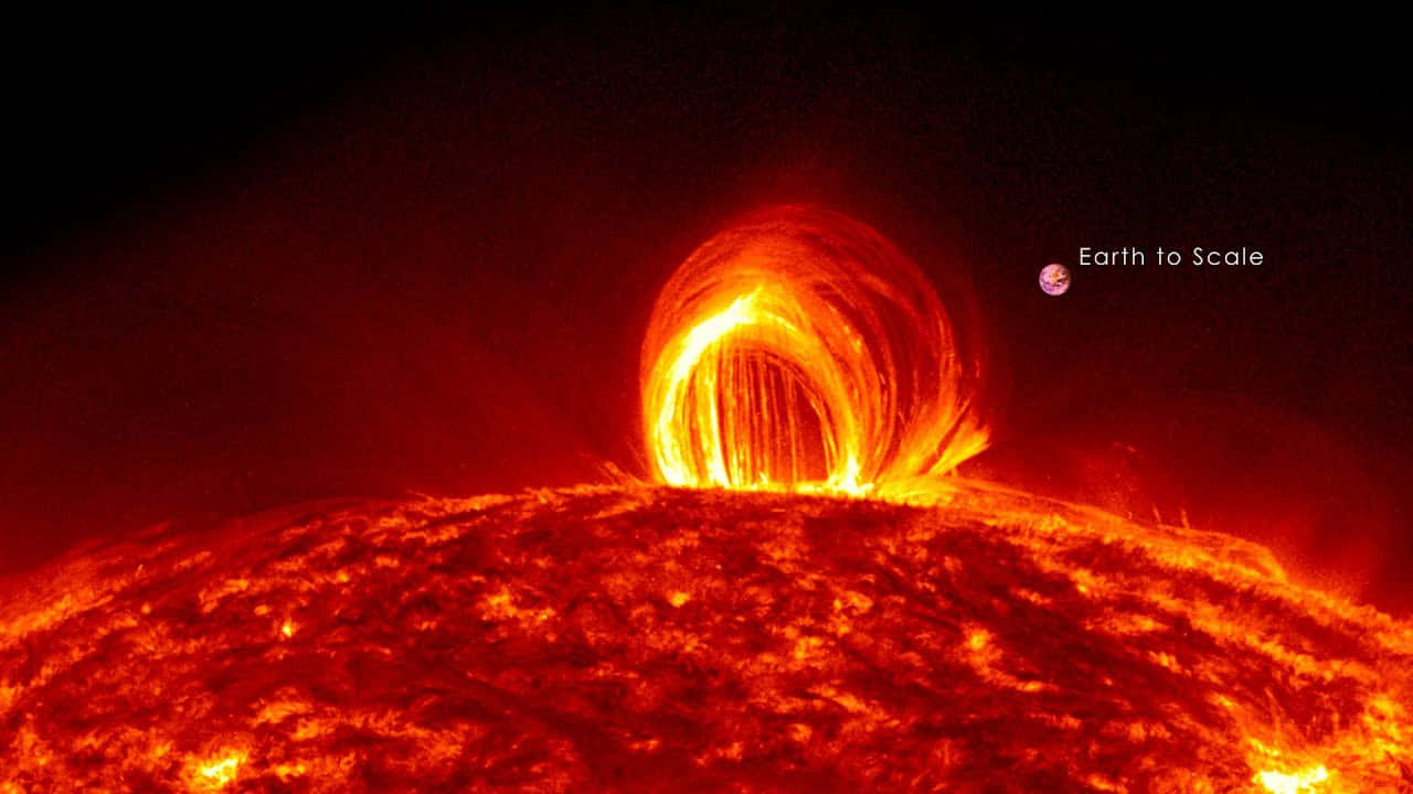太陽 桌布 壁紙 — 巨大的太陽日珥從太陽表面噴發，地球以比例尺顯示在黑暗的太空背景上。