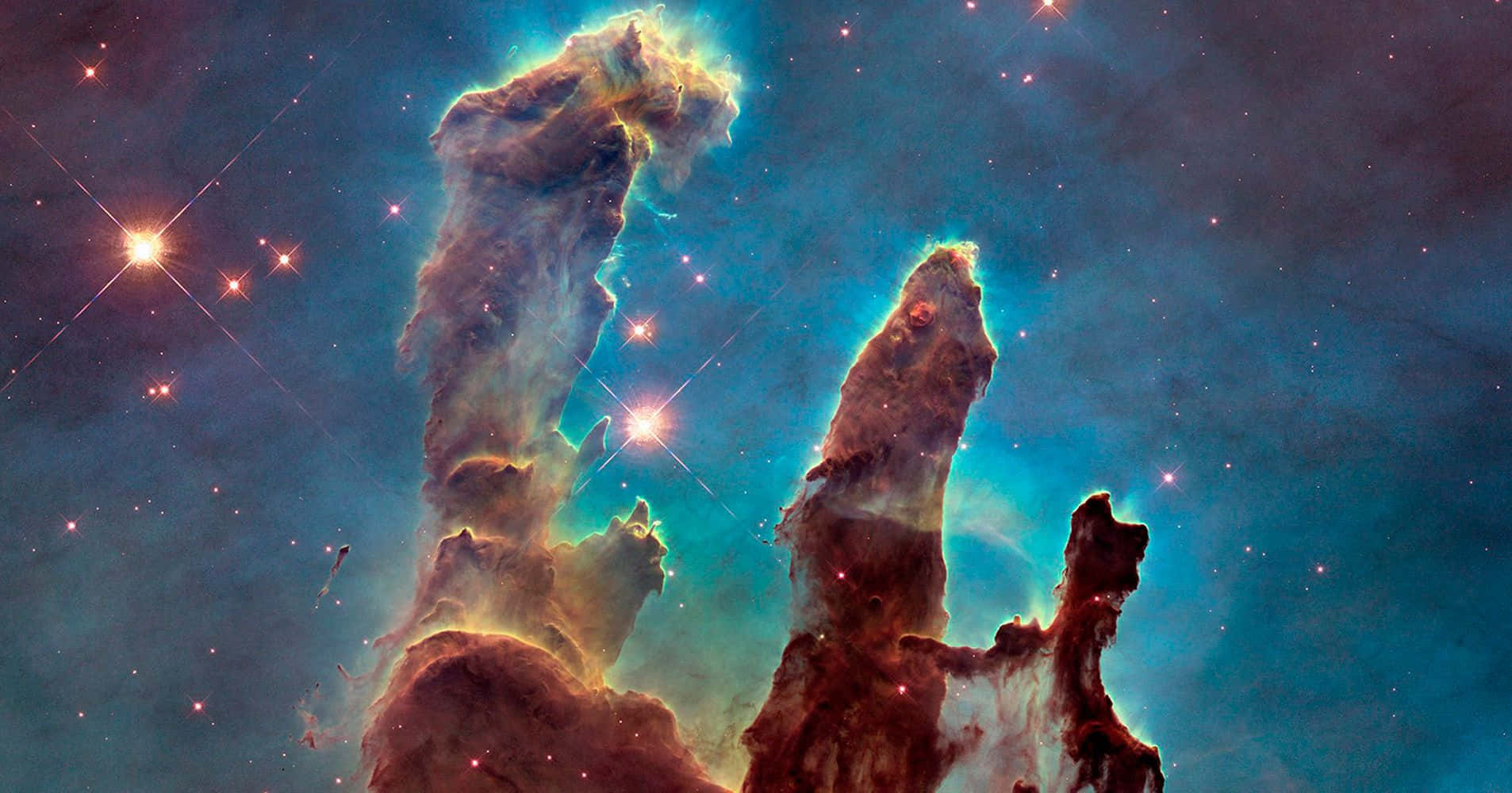 NASA 動態圖片 桌布 壁紙 — 巨大的宇宙柱從發光的星雲中升起，背景是繁星點點和深藍色宇宙塵埃的星空。