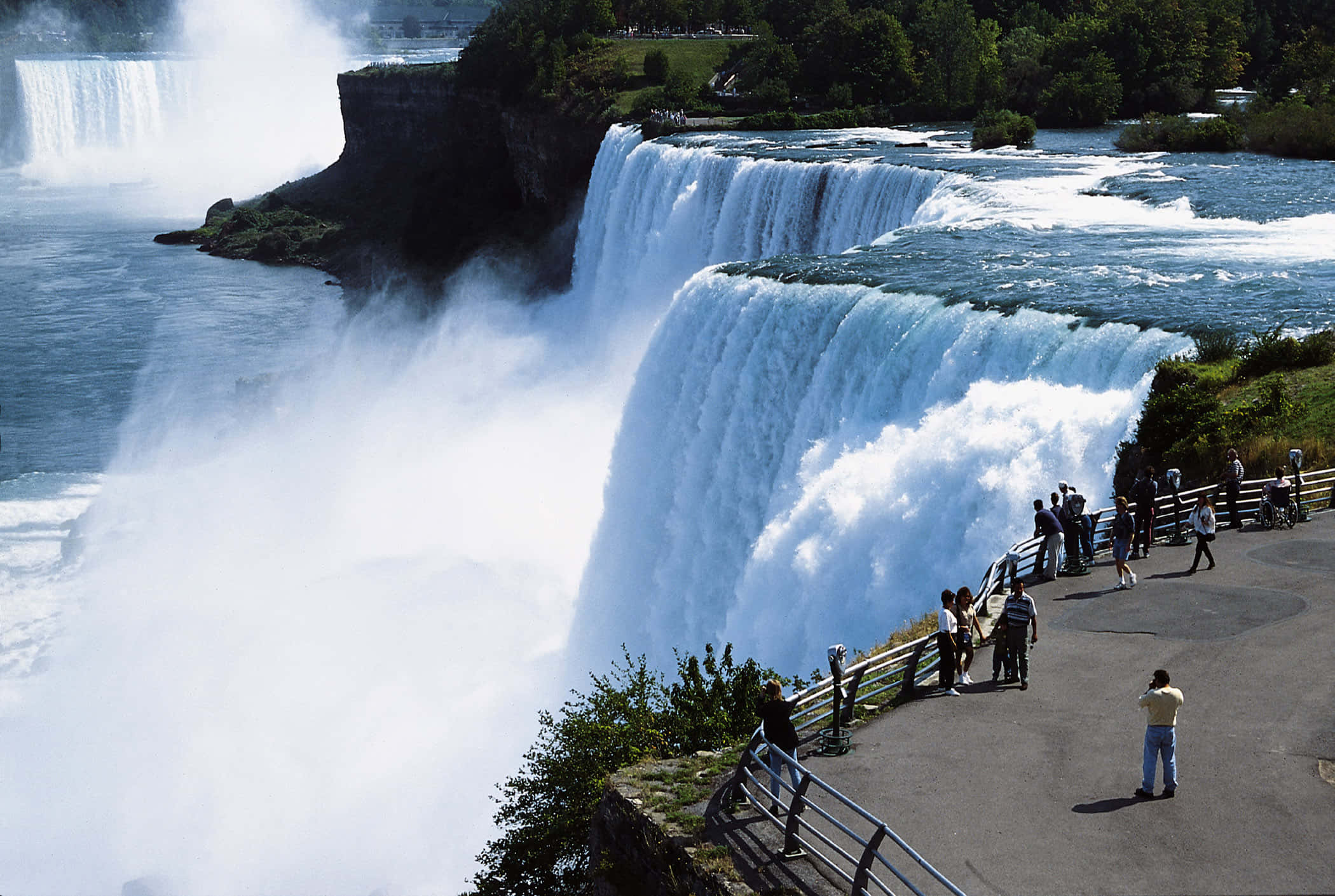 Niagara Falls 桌布 壁紙 — 巨大的層疊瀑布轟鳴，水霧升騰，遊客沿懸崖邊的觀景步道觀賞。