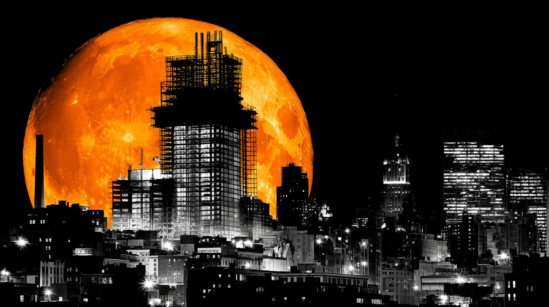 Dramatic Orange Moon over Monochromatic City Skyline 壁紙 — 巨大的橙色月亮出現在單色城市景觀背後，有燈火通明的摩天大樓和建築鷹架。