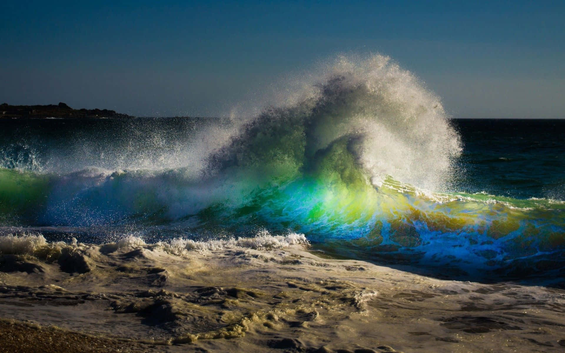 Ocean Waves 桌布 壁紙 — 巨大的海浪以鮮豔的綠色、藍色和黃色色調衝擊沙灘，在清澈的藍天下破碎。