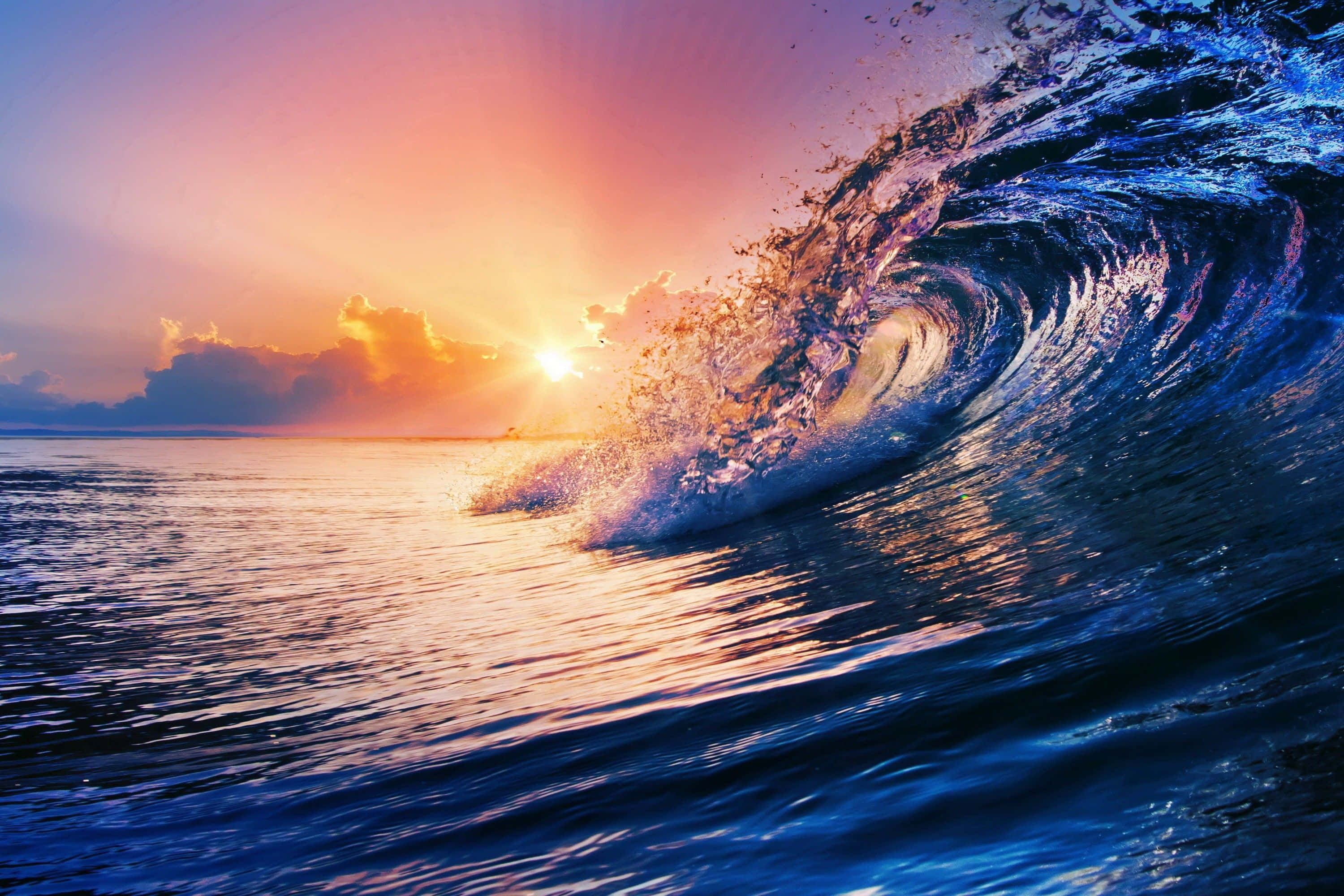 waves 桌布 壁紙 — 巨大的海浪在色彩繽紛的日落天空下翻捲，金色陽光穿透雲層。