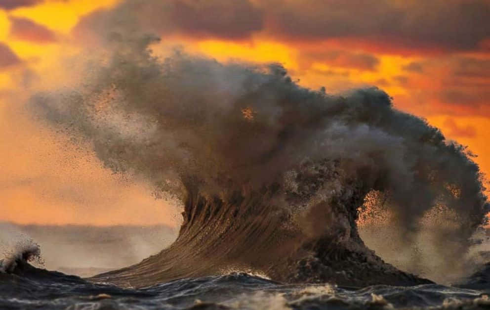 Lake Erie 桌布 壁紙 — 巨大的海浪帶著霧氣般的水花，撞向火熱的橙色和紫色日落天空。