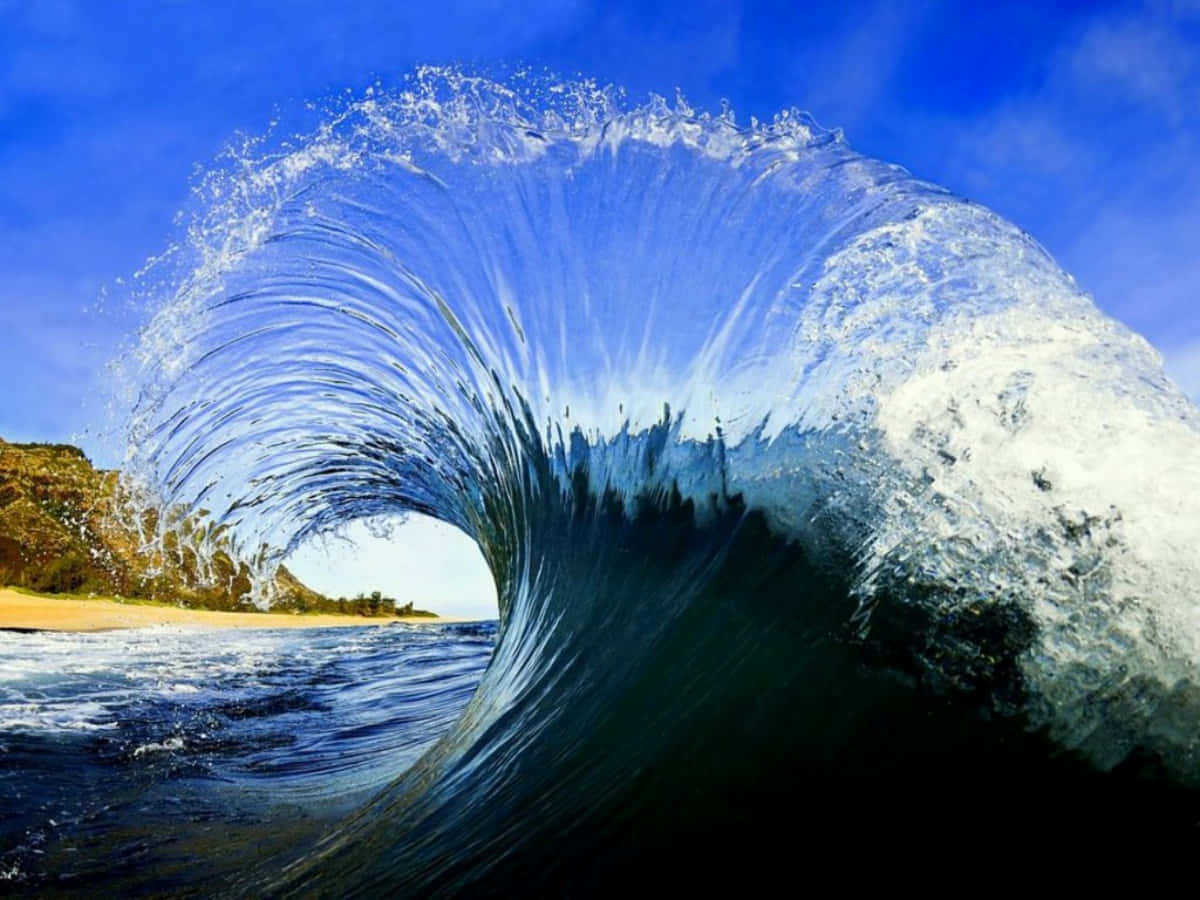Wave 桌布 壁紙 — 巨大的海浪捲成完美的管浪，帶有藍綠色的海水和白色泡沫，映襯著清澈的藍天。