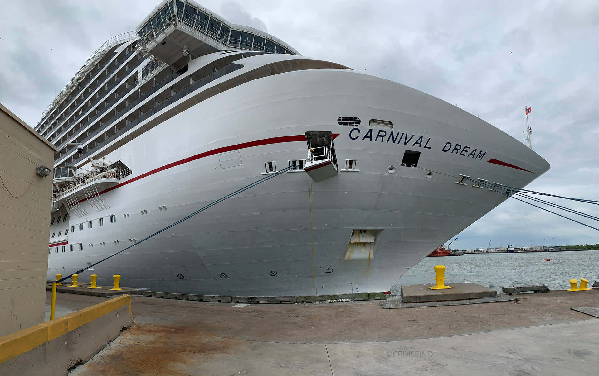 Carnival Dream 桌布 壁紙 — 巨大的白色郵輪 Carnival Dream 停泊在碼頭，天空多雲，船首清晰可見其名稱。
