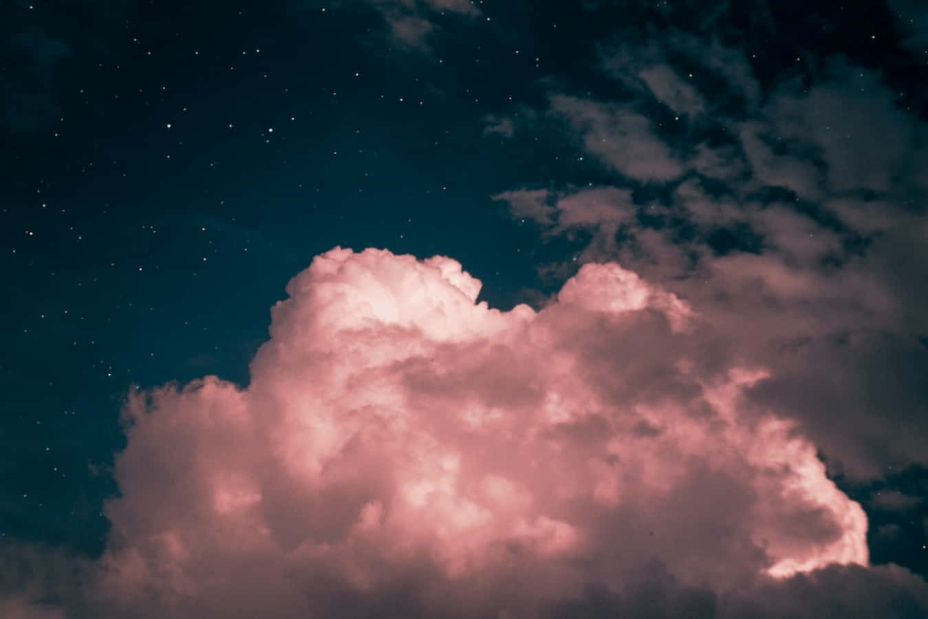 雲朵 桌布 壁紙 — 巨大的粉紅色雲朵在繁星點點的夜空下被照亮，帶有深藍綠色調。
