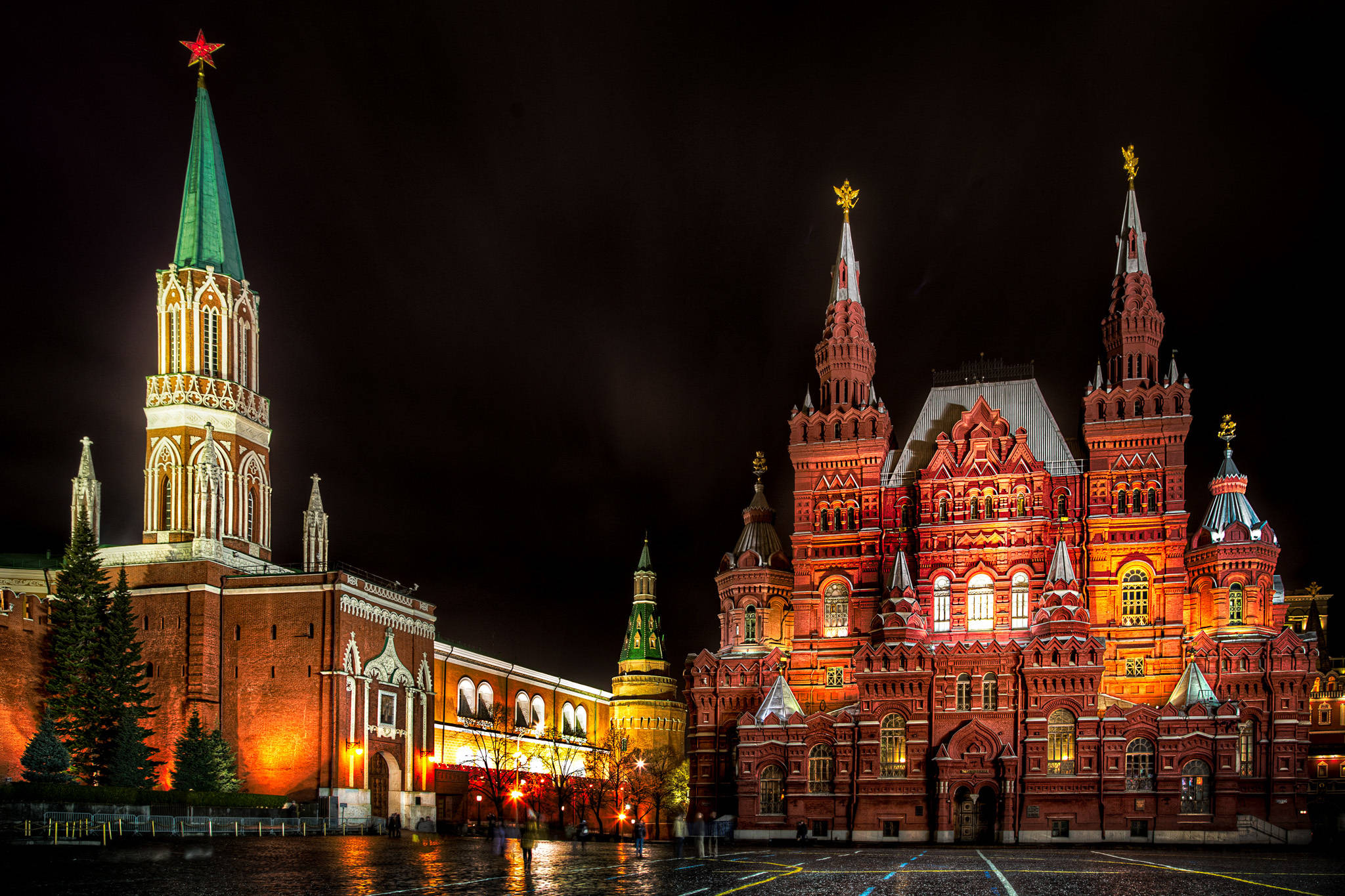 Russia 桌布 壁紙 — 巨大的紅磚克里姆林宮和國家歷史博物館在夜晚被金色燈光照亮，反射在濕漉漉的鵝卵石上。
