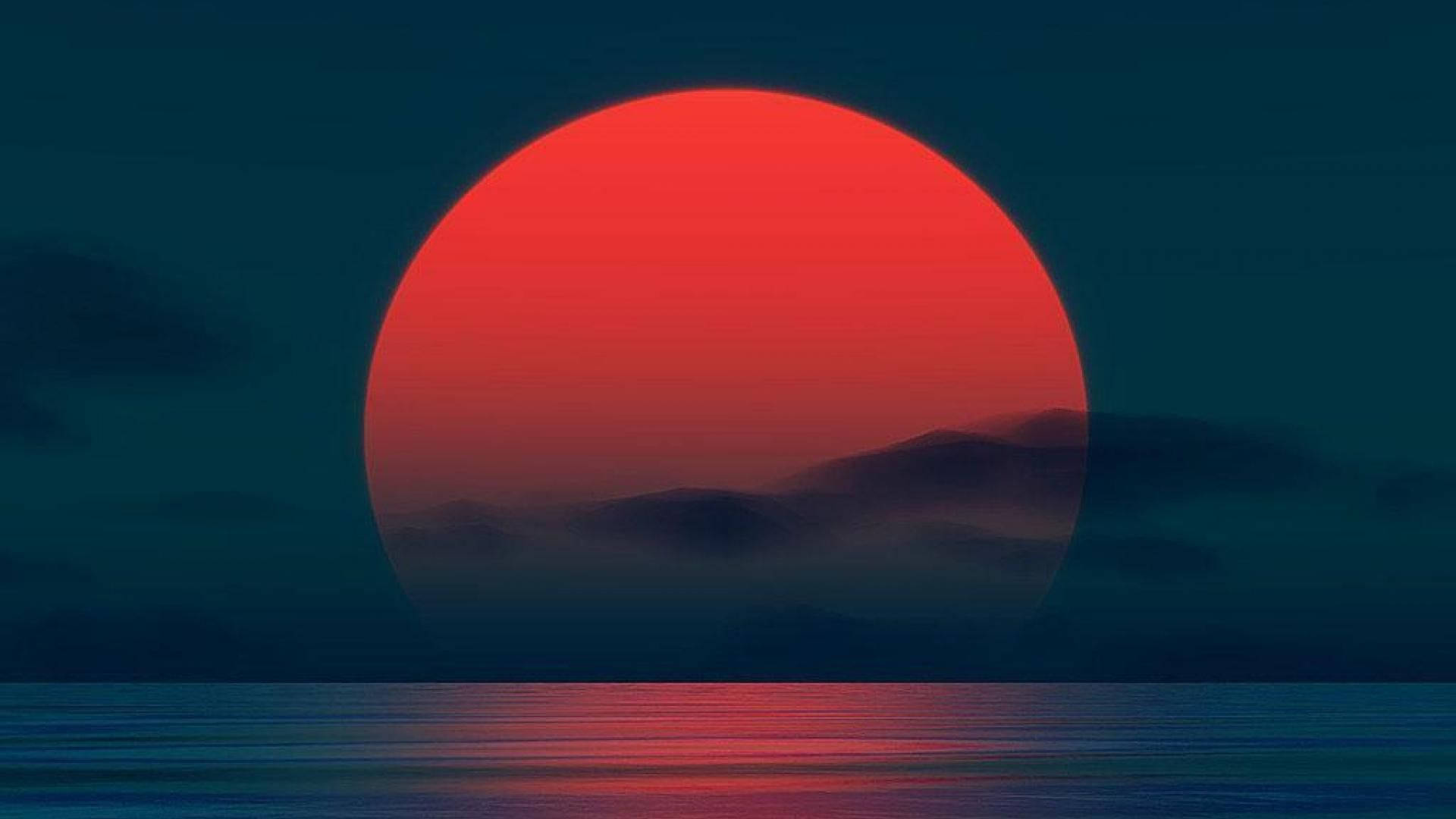 旭日東昇 桌布 壁紙 — 巨大的紅色夕陽落在霧氣繚繞的山巒上，倒映在平靜的海面上，天空呈現深藍綠色。
