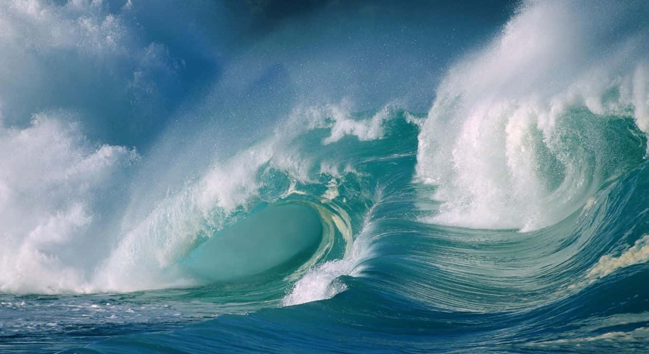 Tides 桌布 壁紙 — 巨大的藍綠色海浪在暴風雨的天空下捲成完美的筒狀，周圍白色泡沫四濺。