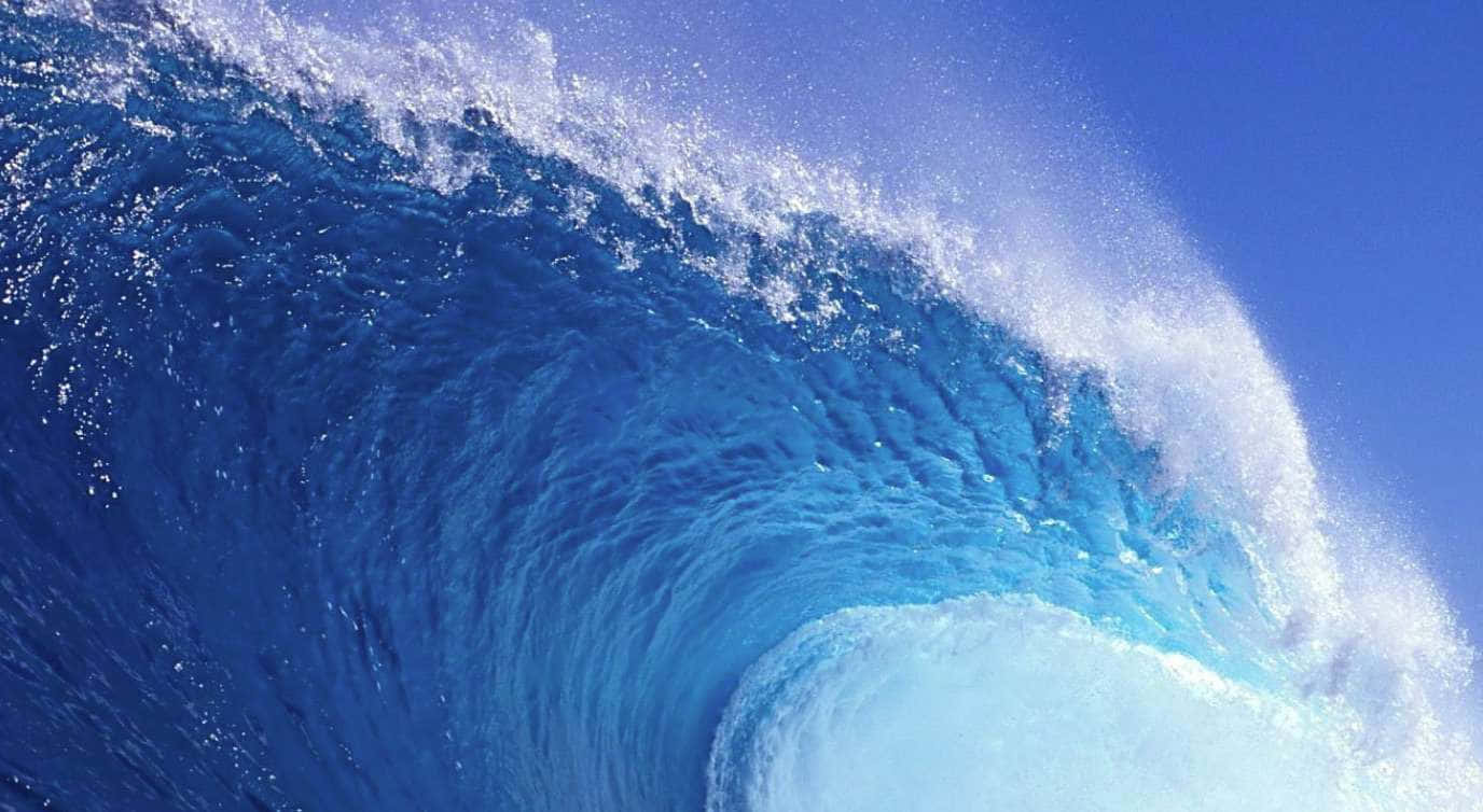 Sea 桌布 壁紙 — 巨大的藍綠色海浪在清澈的藍天下捲成完美的桶狀。