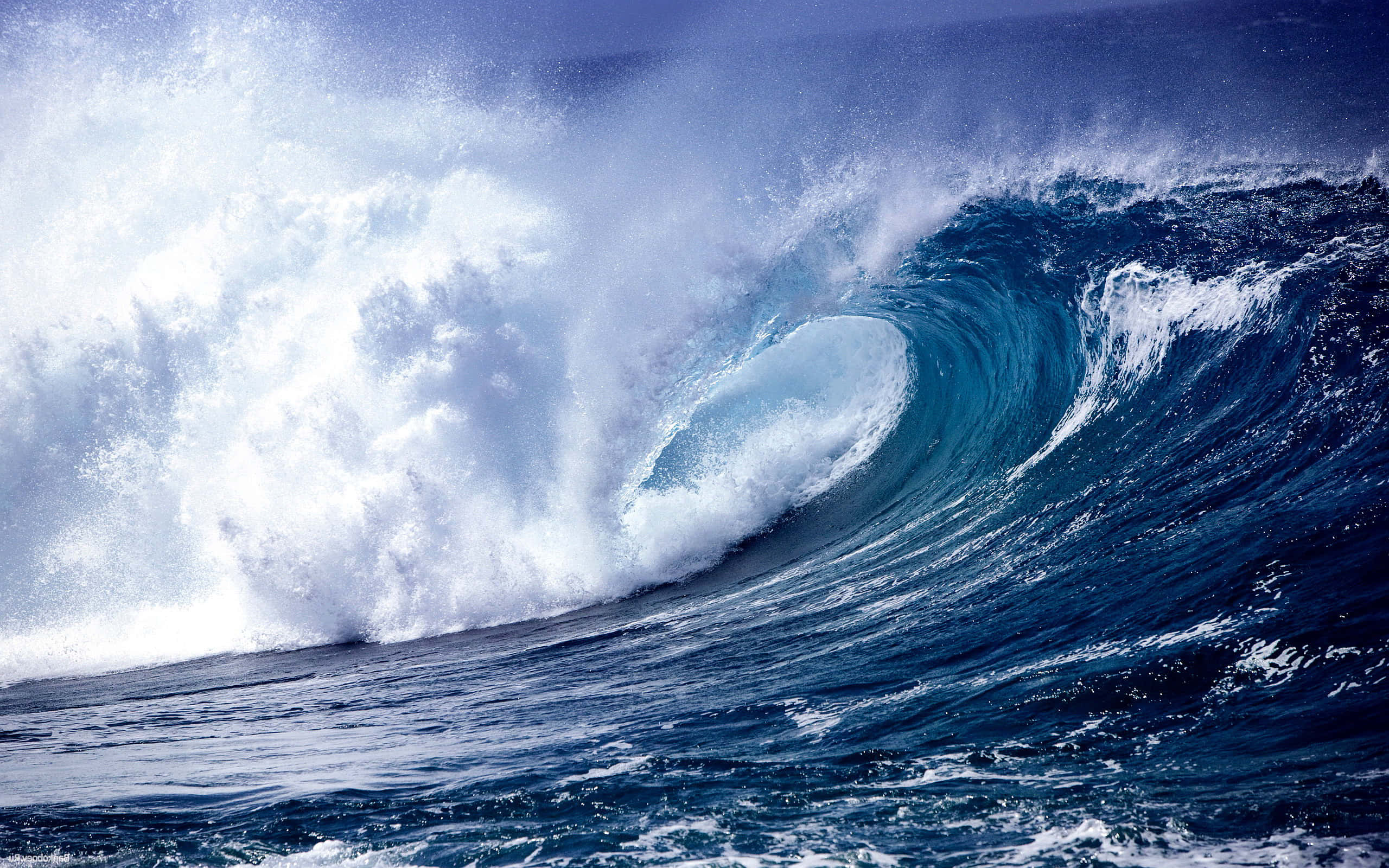 Wave 桌布 壁紙 — 巨大的藍綠色海浪捲成完美的管浪，白色泡沫飛濺，襯托著深藍色的天空。
