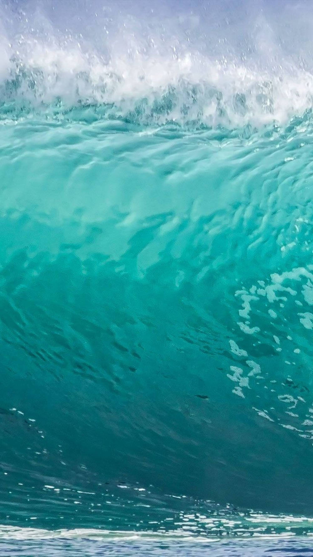 Ocean iPhone 桌布 壁紙 — 巨大的藍綠色海浪捲起，帶著白色泡沫飛濺，映襯著淡藍色的天空。