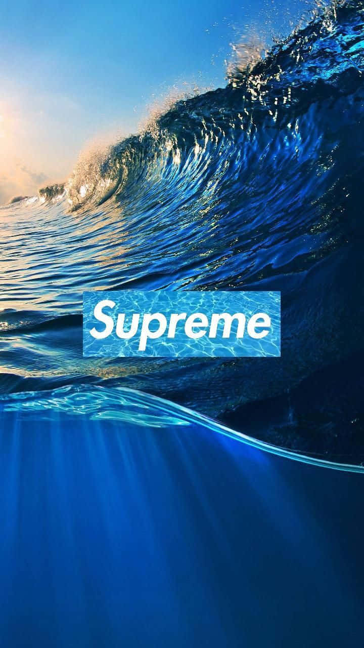 blue supreme 桌布 壁紙 — 巨大的藍色海浪在頭頂翻捲，陽光在其頂峰閃爍，一個白色的Supreme標誌漂浮在水中。