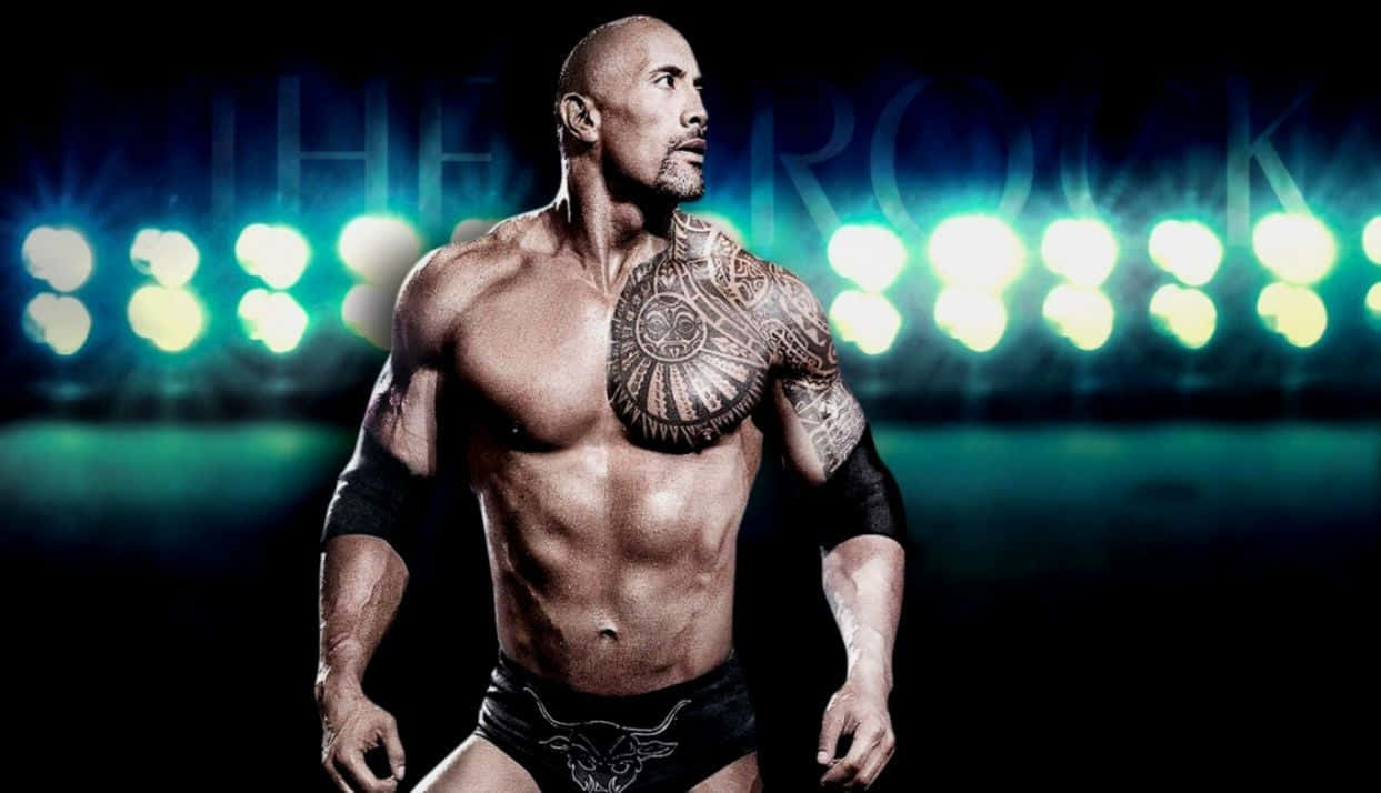 The Rock 桌布 壁紙 — 巨石強森身穿摔角裝備，在明亮的綠色舞台燈光下強勢站立，身後『THE ROCK』字樣閃耀。