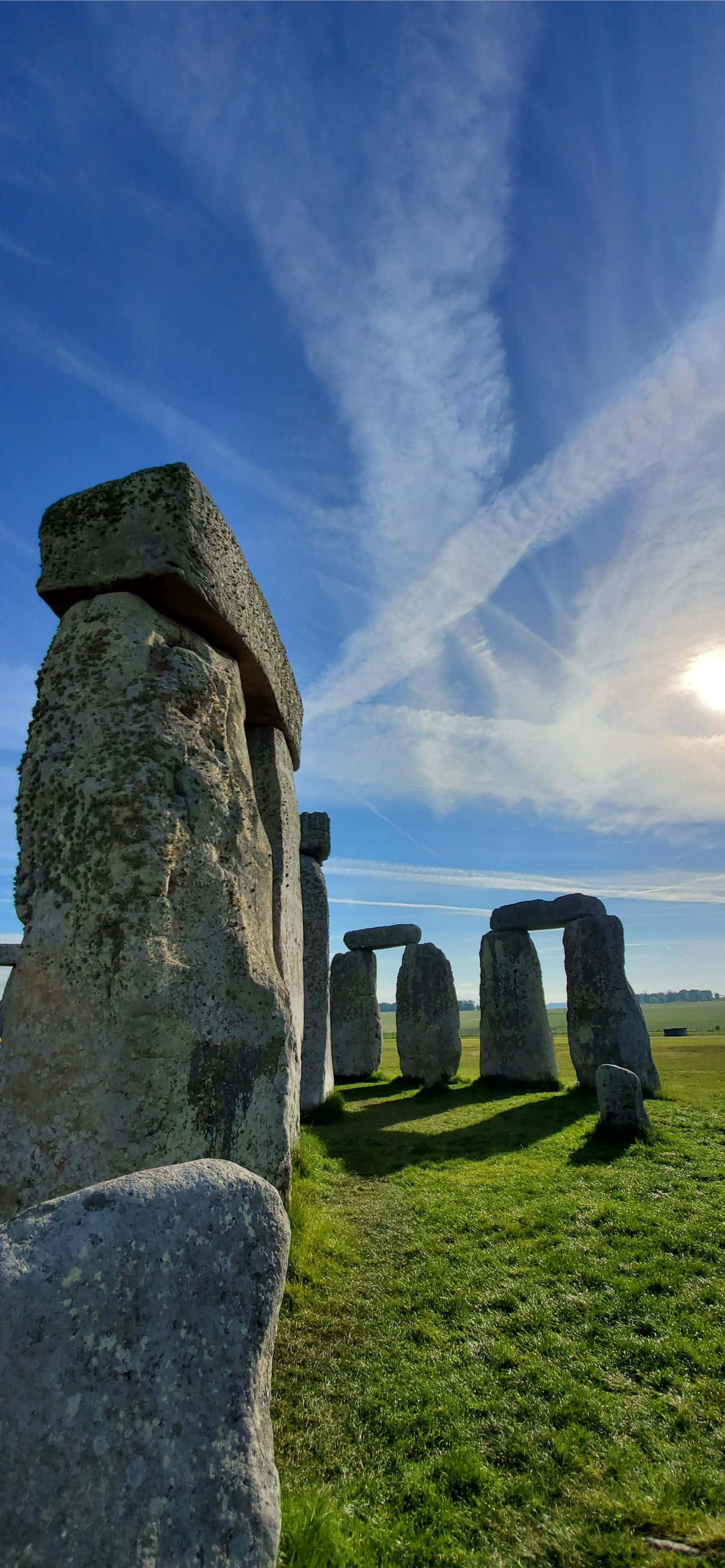 England 桌布 壁紙 — 巨石陣的古老立石在佈滿縷縷白雲的鮮豔藍天下雄偉地聳立。