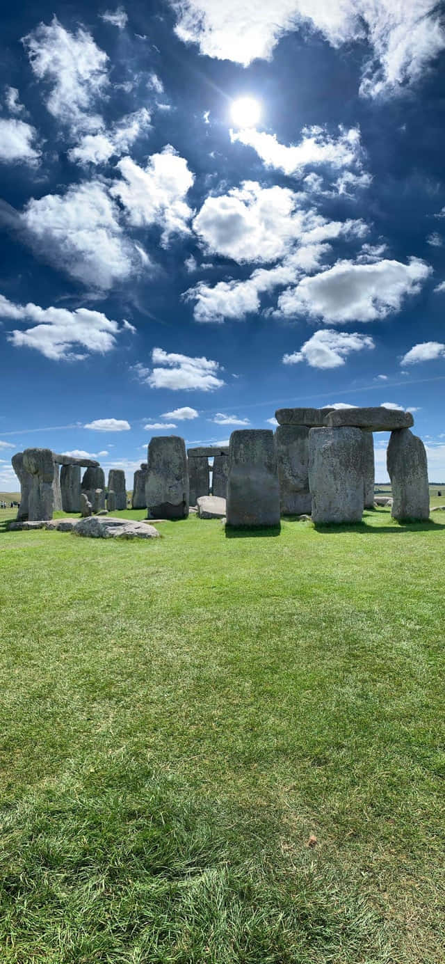 England 桌布 壁紙 — 巨石陣的古老立石在點綴著蓬鬆白雲的明亮藍天下雄偉地聳立。