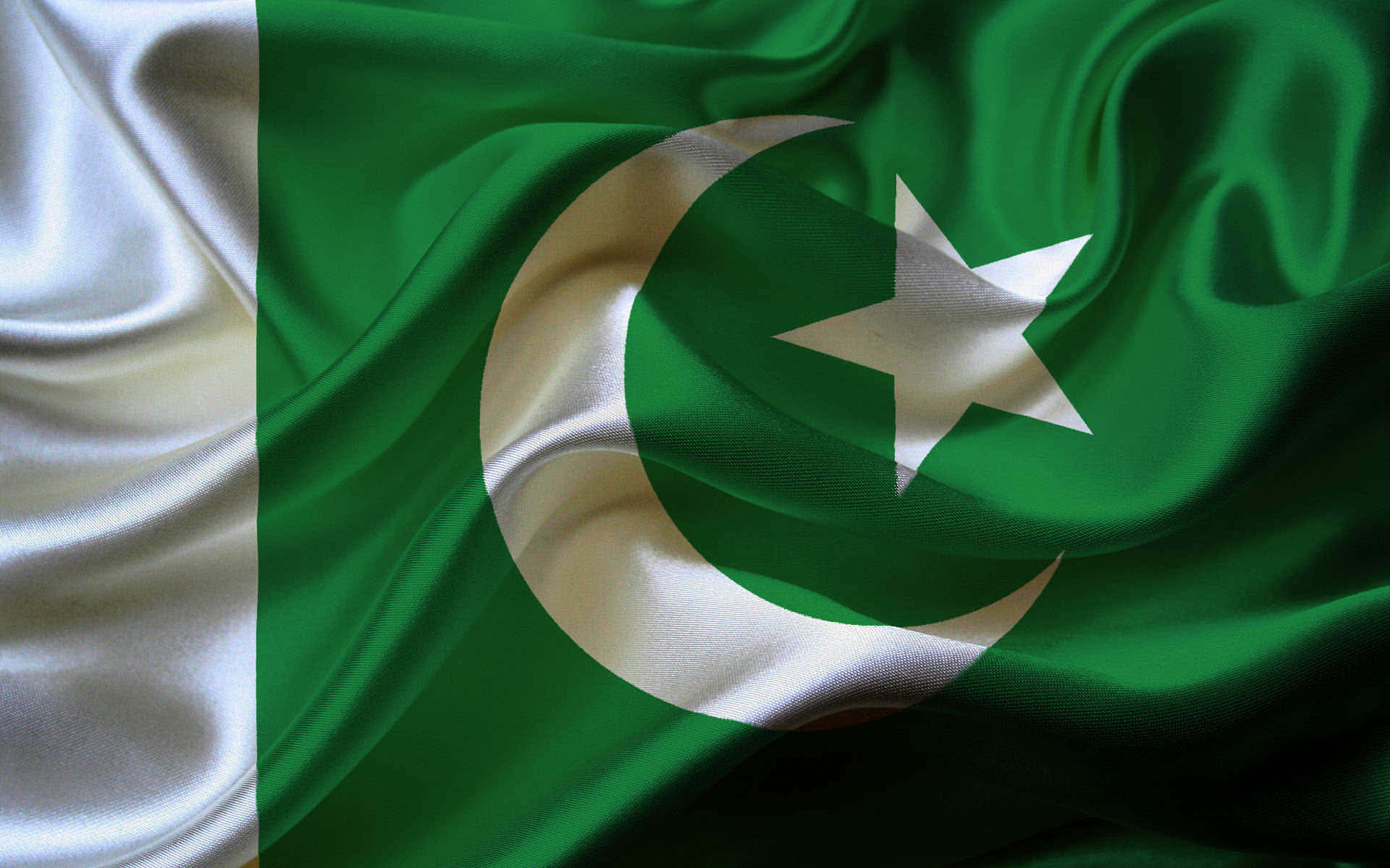 Pakistan 桌布 壁紙 — 巴基斯坦國旗的特寫，綠色和白色的布料隨風飄揚，展現出細緻的摺痕和高光。