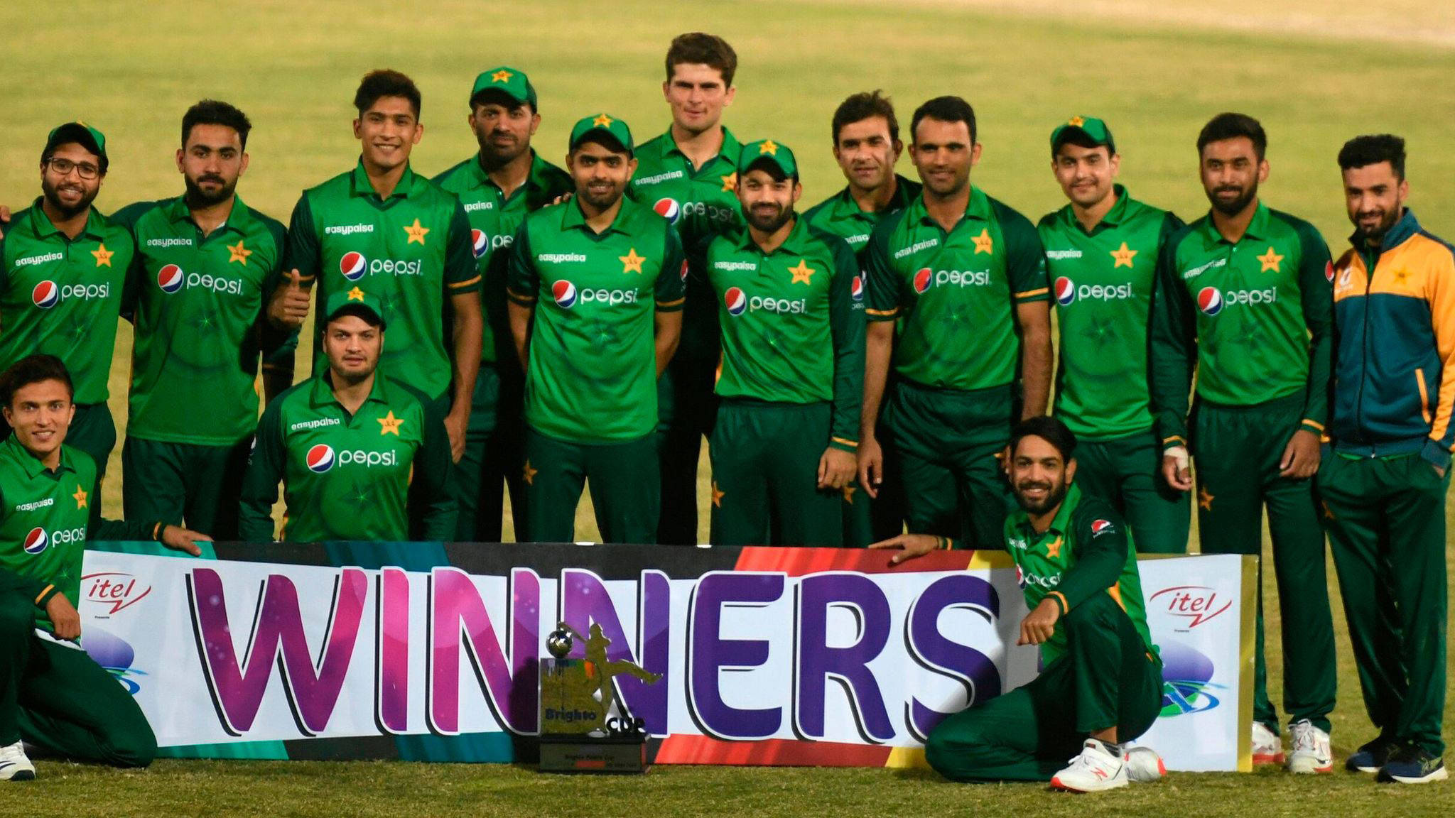 Pakistan Cricket 桌布 壁紙 — 巴基斯坦板球隊身穿綠色制服，在草地上手持獎盃和「WINNERS」橫幅慶祝勝利。