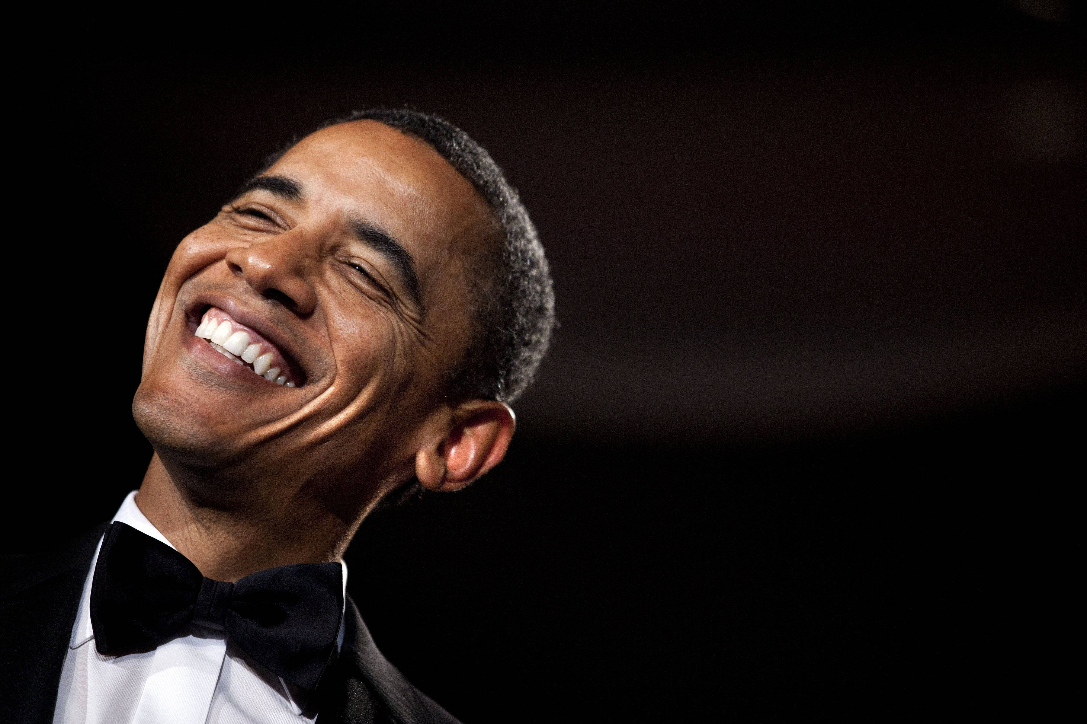 Barack 桌布 壁紙 — 巴拉克·歐巴馬穿著燕尾服在深色背景下開懷大笑，眼睛因喜悅而瞇起。