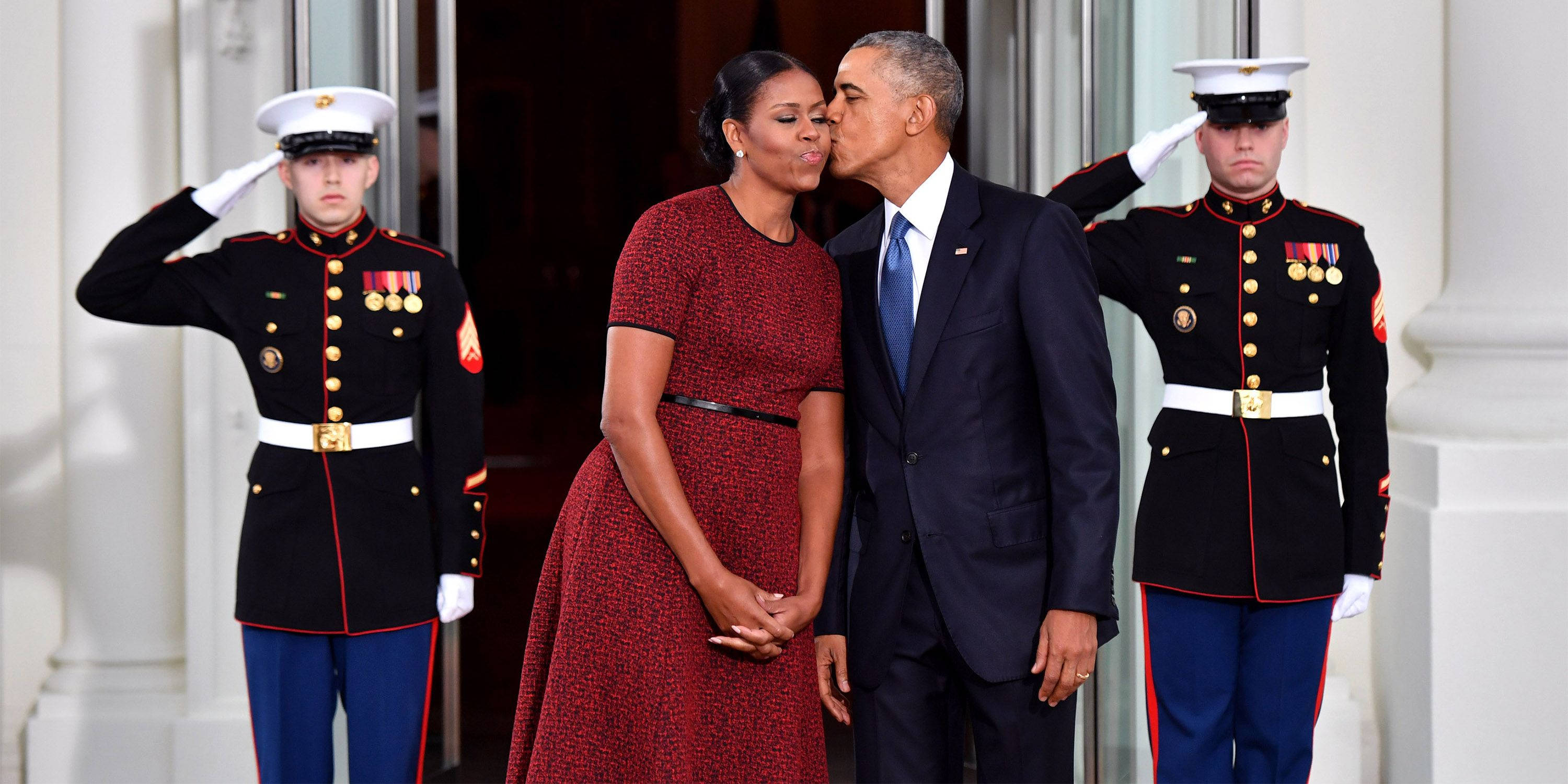 Michelle 桌布 壁紙 — 巴拉克和蜜雪兒·歐巴馬在白色柱建築前分享一個溫柔的吻，兩名身穿制服的海軍陸戰隊員向他們敬禮。