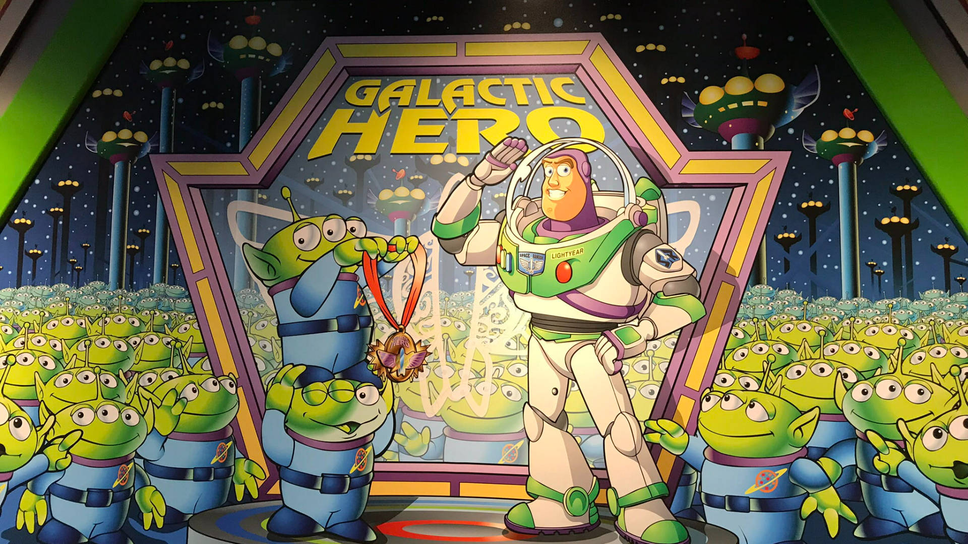 迪士尼 桌布 壁紙 — 巴斯光年自豪地站在舞台上，一群綠色外星人在星空下為他歡呼，視他為銀河英雄。
