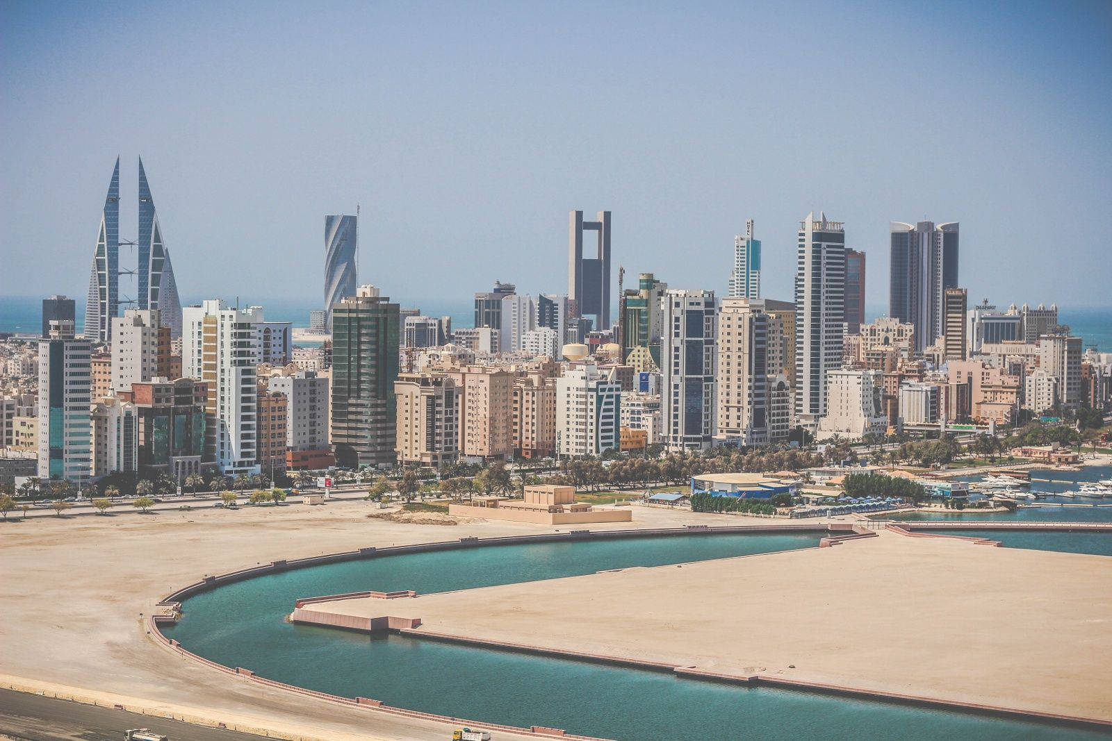 Bahrain 桌布 壁紙 — 巴林現代天際線的全景，擁有標誌性摩天大樓和碧綠水道，在清澈的藍天下。