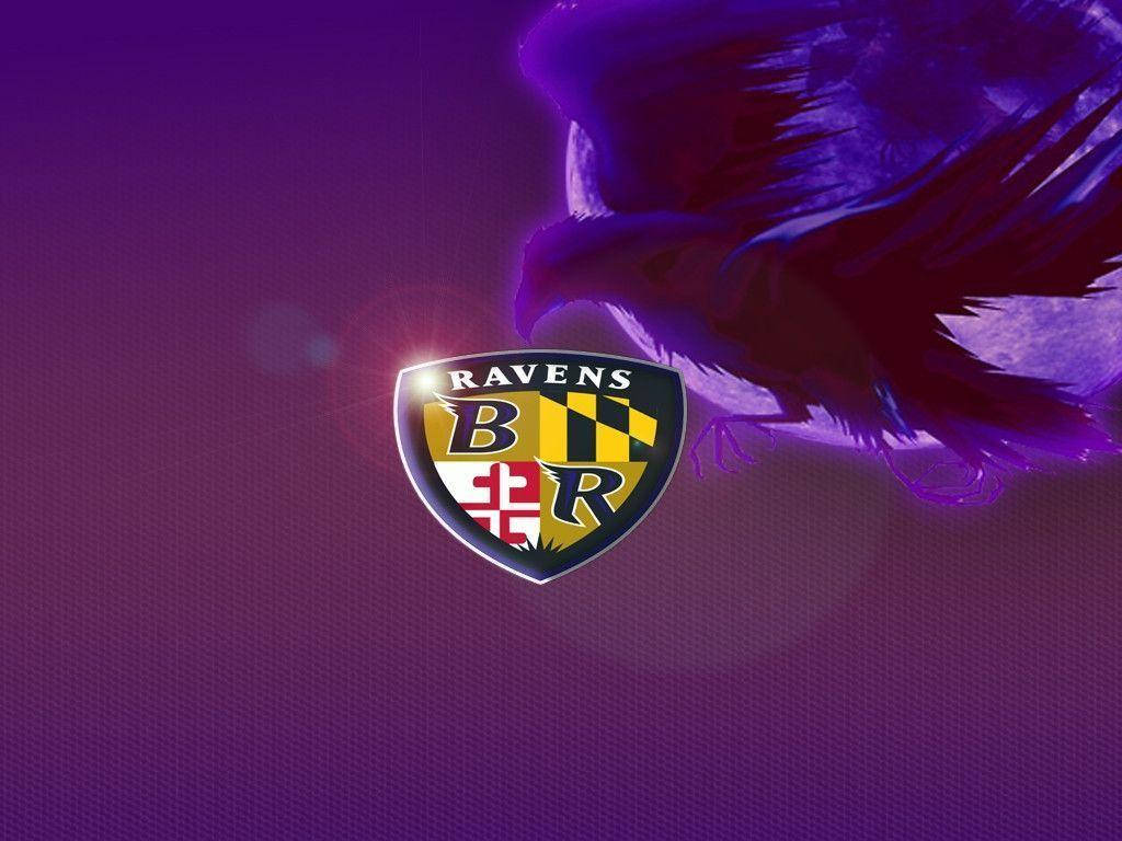 Ravens 桌布 壁紙 — 巴爾的摩烏鴉隊標誌在紫色燈光下閃耀，背後隱約出現烏鴉剪影。