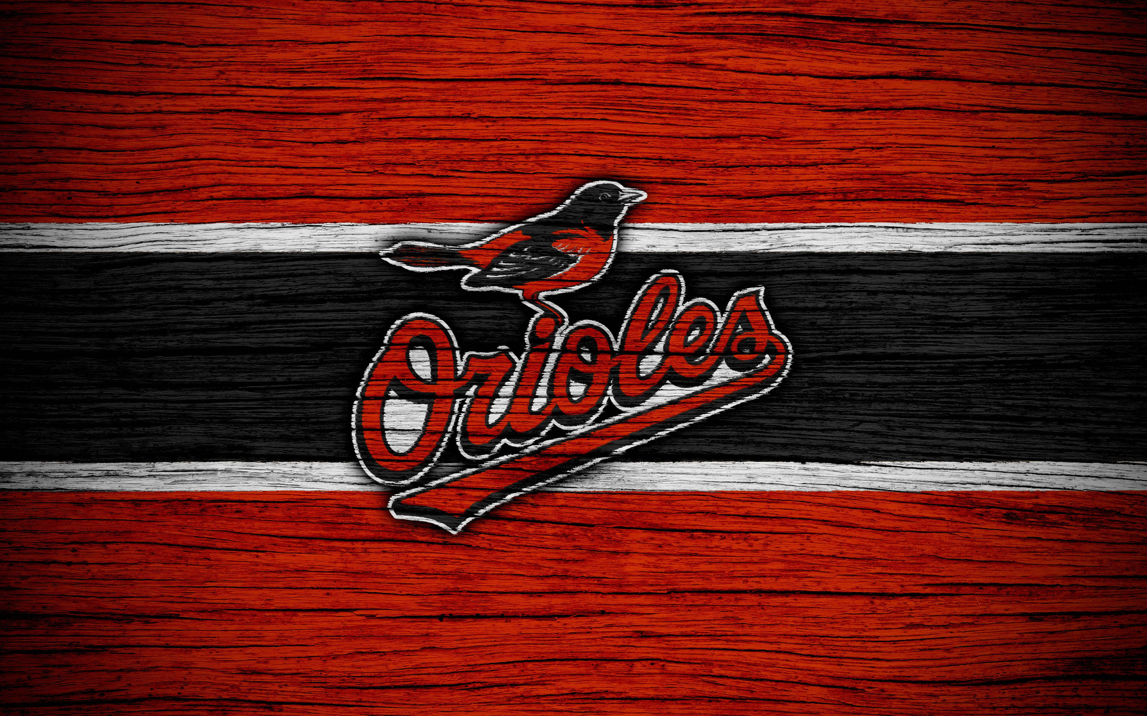 Orioles 桌布 壁紙 — 巴爾的摩金鶯隊標誌，鳥兒棲息在草書字體上，背景為紅、黑、白木紋。