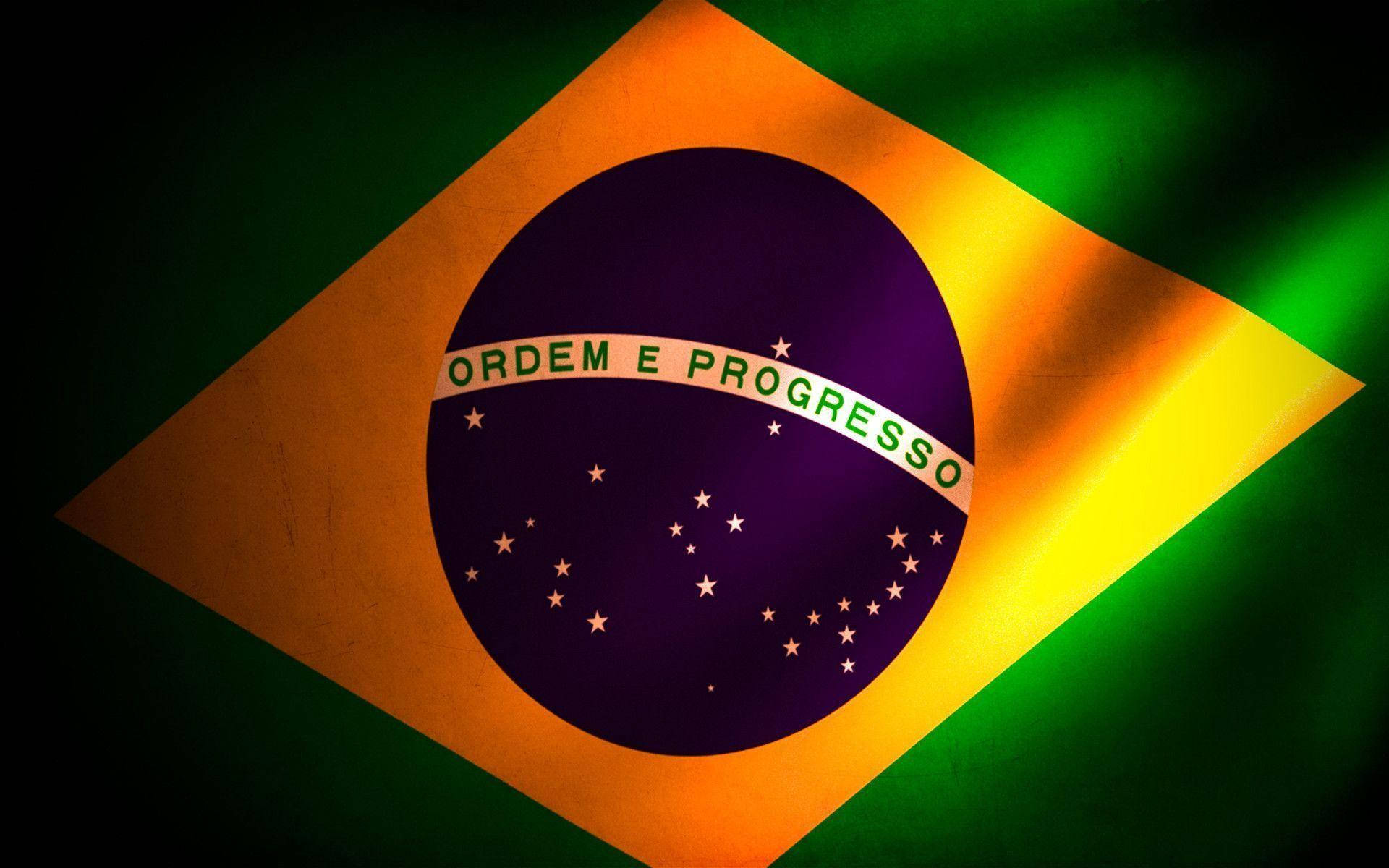 Brazil Flag 桌布 壁紙 — 巴西國旗以綠色、黃色和紫色在深色背景上動態飄揚。