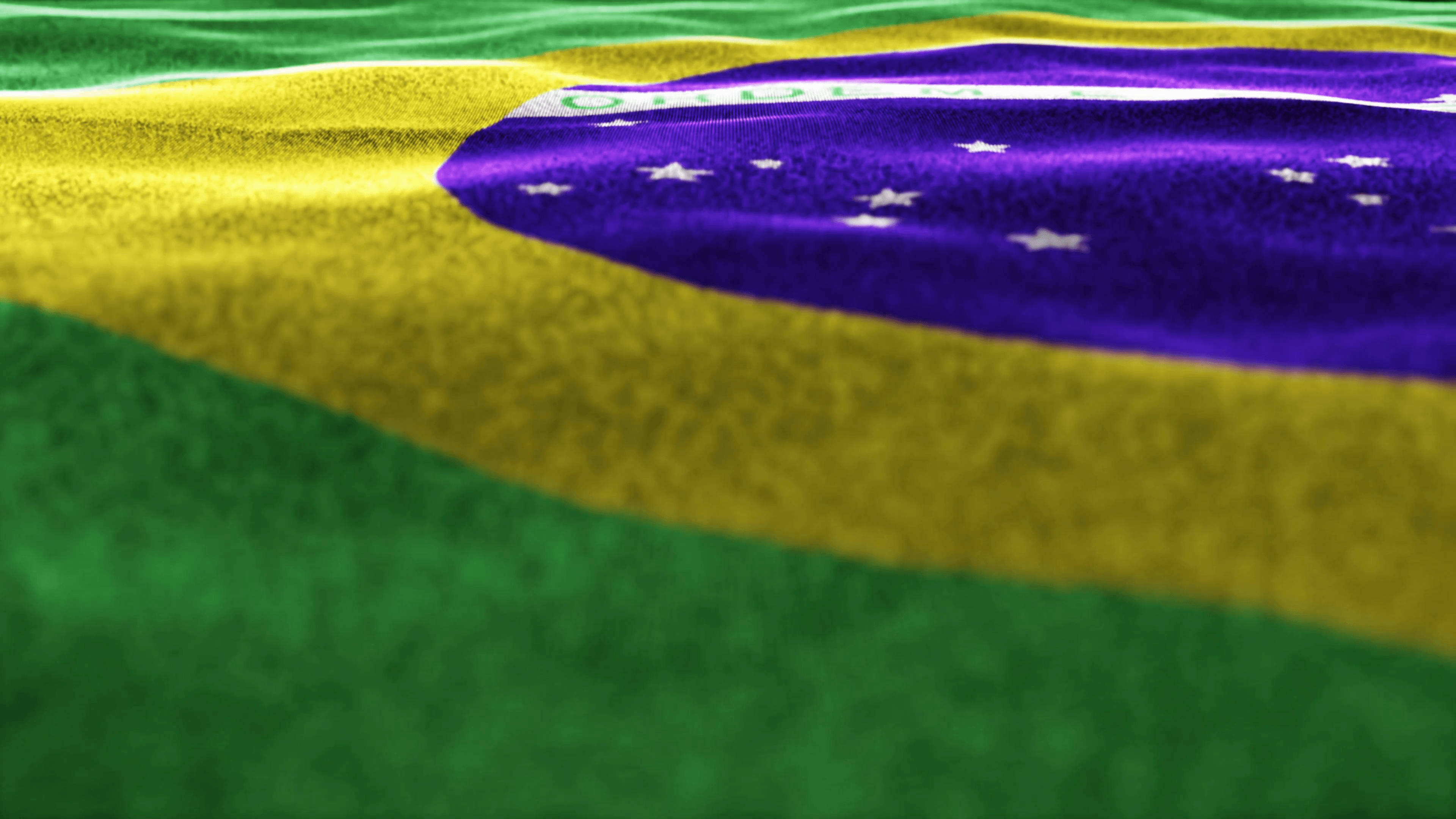 Brazil Flag 桌布 壁紙 — 巴西國旗布料近距離特寫，飄揚著鮮豔的綠色、黃色和紫色以及白色星星。
