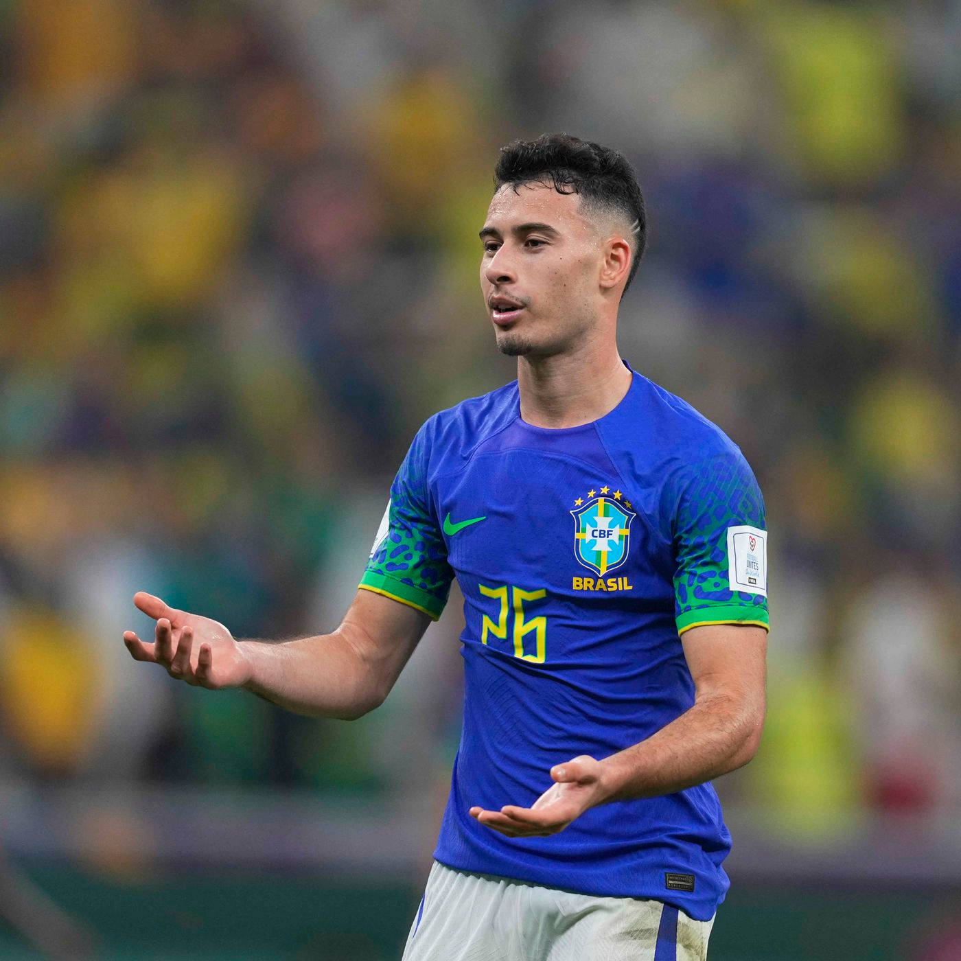 Football Players 桌布 壁紙 — 巴西足球員26號身穿藍色球衣在球場燈光下比賽時用手勢示意。