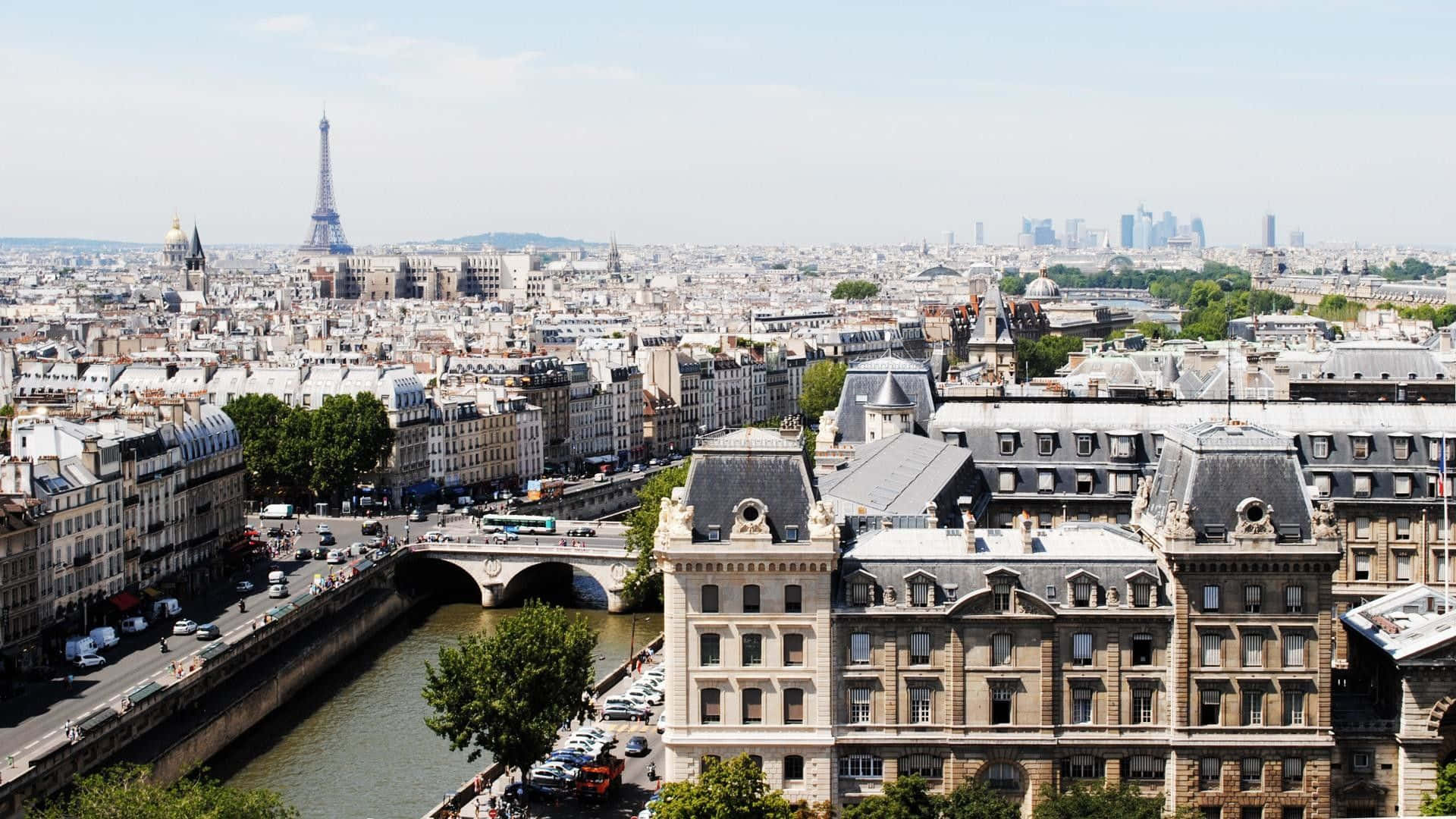 Paris Desktop 桌布 壁紙 — 巴黎全景，展示艾菲爾鐵塔、歷史建築和塞納河，天空晴朗。