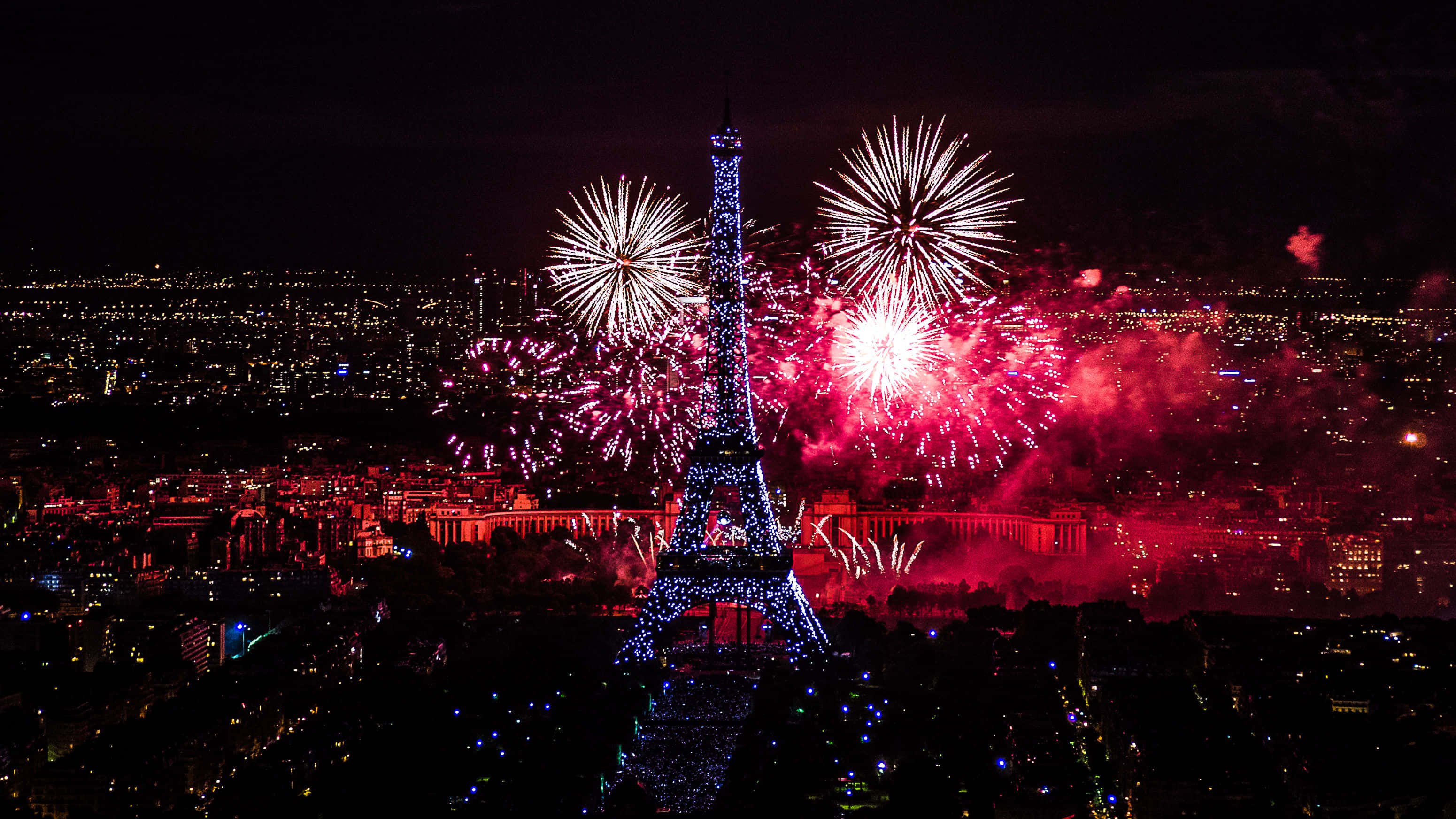 Eiffel Tower 桌布 壁紙 — 巴黎天際線上綻放耀眼的紅白煙火，夜晚的艾菲爾鐵塔燈火輝煌。