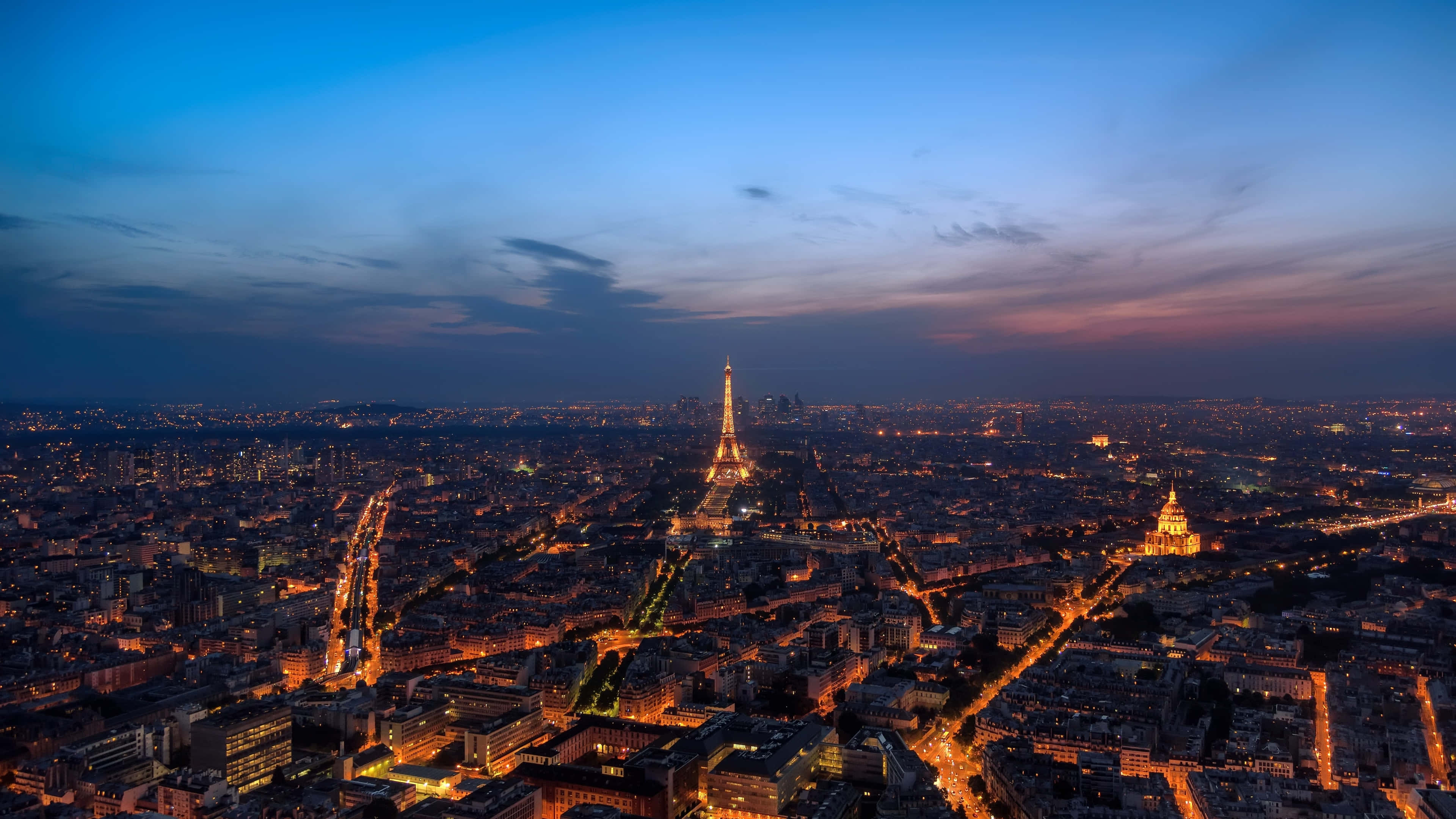 Paris At Night 桌布 壁紙 — 巴黎天際線在黃昏時分，艾菲爾鐵塔在藍粉漸變的天空中閃耀。