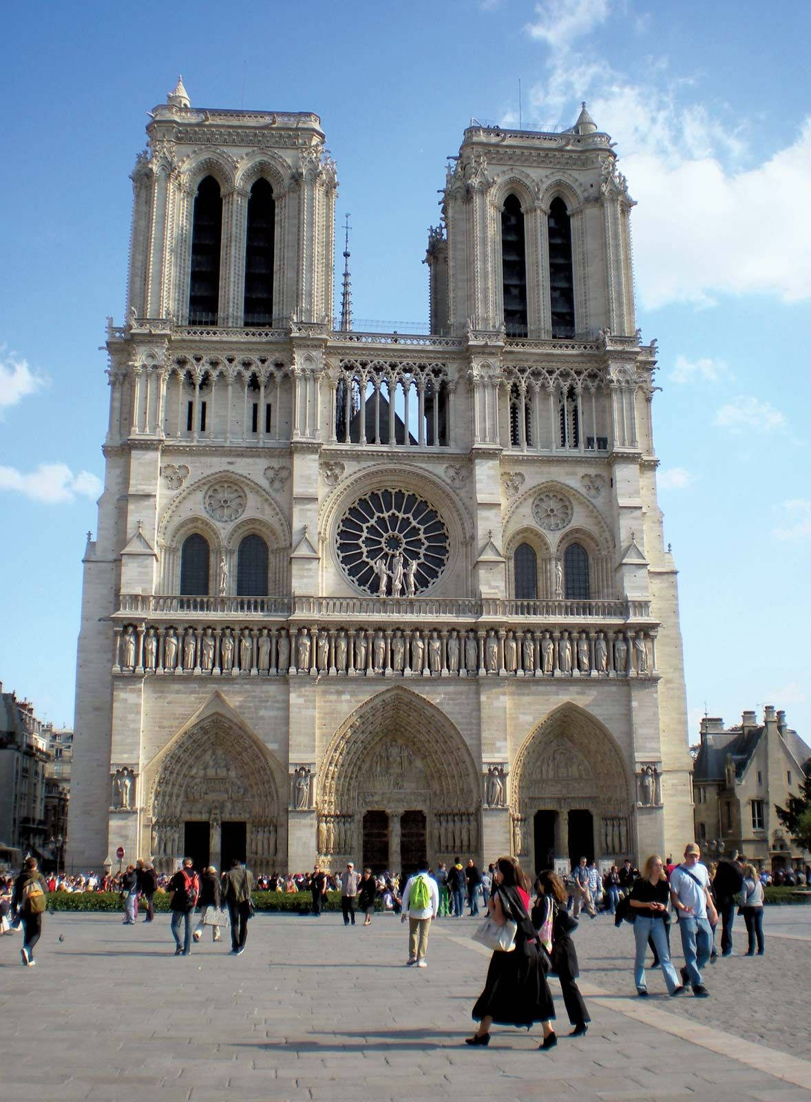 Notre Dame 桌布 壁紙 — 巴黎宏偉的哥德式聖母院，遊客在明亮的藍天下走在前面。