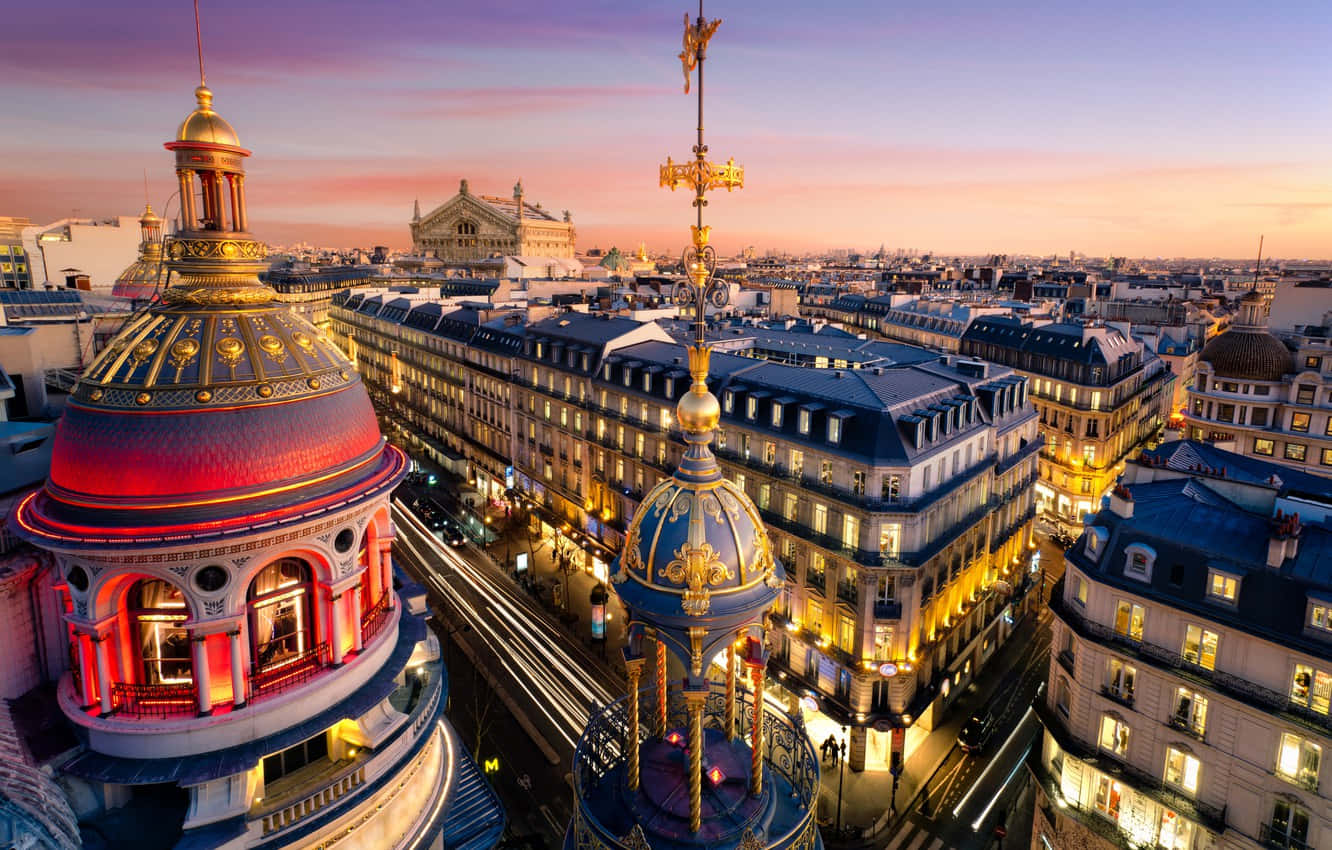 Paris At Night 桌布 壁紙 — 巴黎的屋頂在粉紅色和紫色的日落天空下閃耀著金色的光芒。