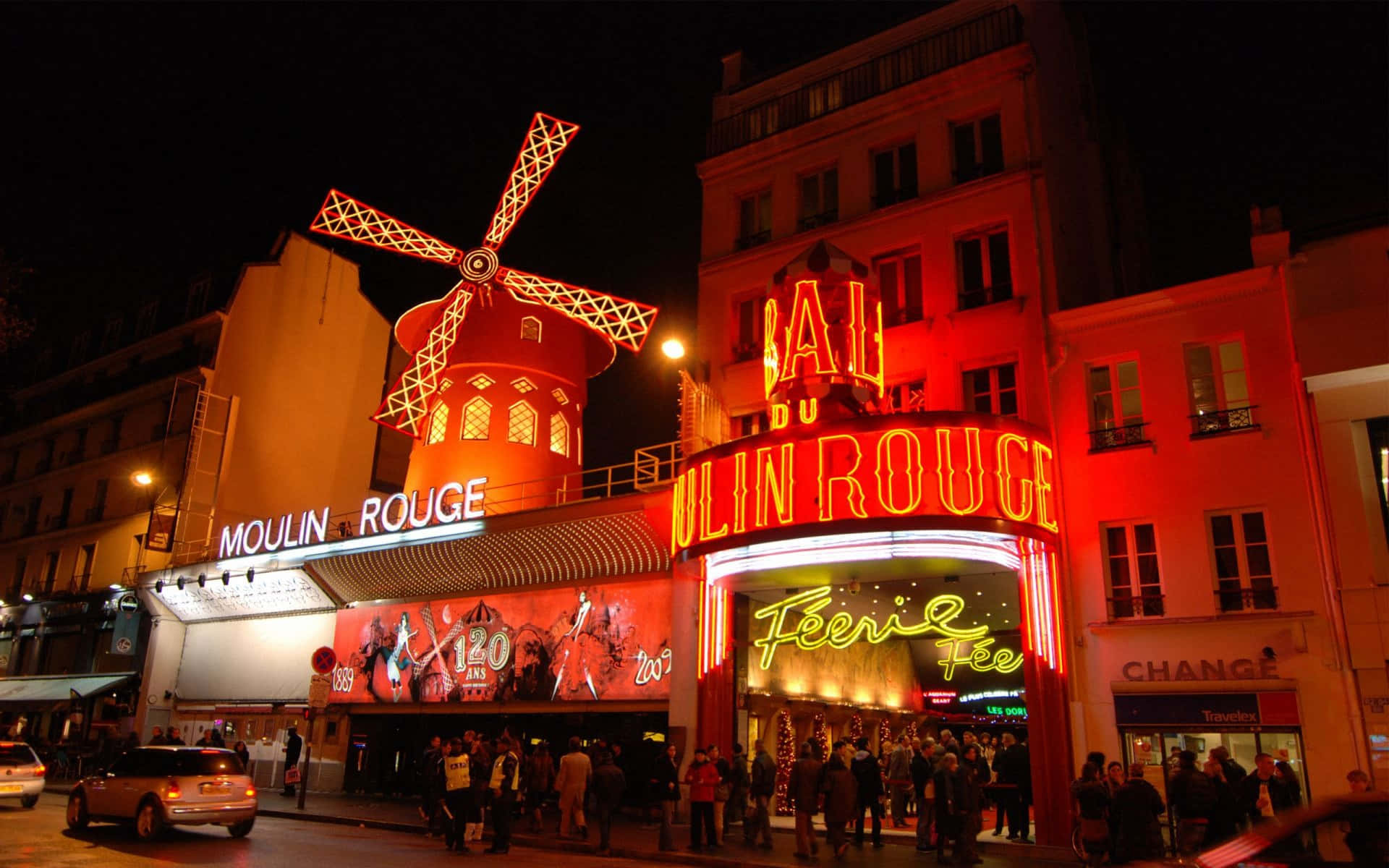 moulin rouge 桌布 壁紙 — 巴黎紅磨坊的璀璨夜景，其標誌性的紅色風車和閃爍的霓虹燈照亮了繁華的街道。