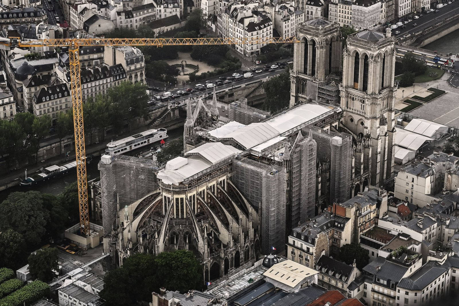 Notre Dame 桌布 壁紙 — 巴黎聖母院修復中的鳥瞰圖，起重機和臨時屋頂在歷史城市景觀中。