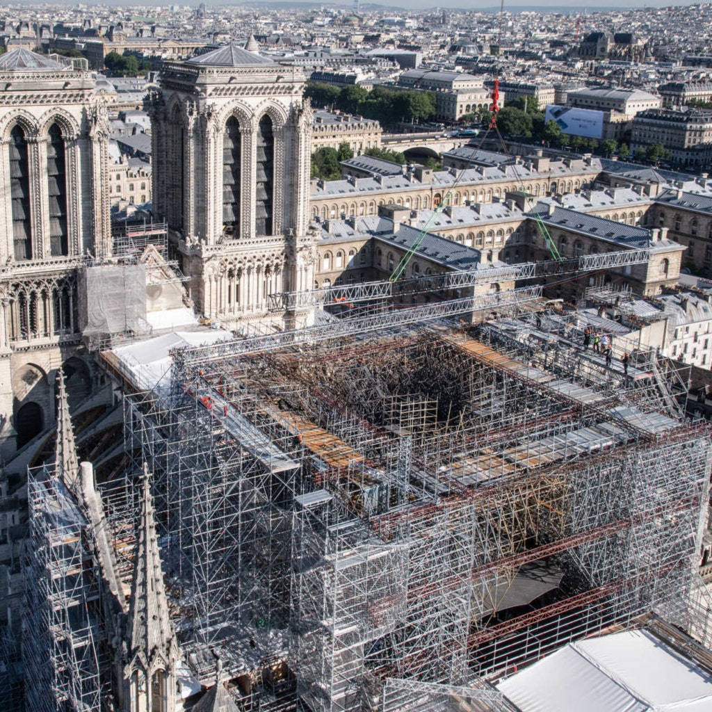 Notre Dame 桌布 壁紙 — 巴黎聖母院的鳥瞰圖，正在進行大規模修復，鷹架覆蓋其受損的屋頂和尖塔。