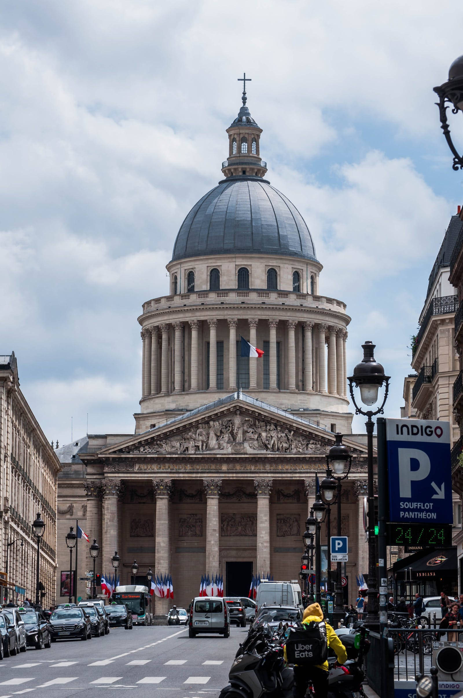 france iPhone 桌布 壁紙 — 巴黎萬神殿的新古典主義圓頂宏偉地聳立在繁忙的街道上，街道兩旁是歷史建築和法國國旗。