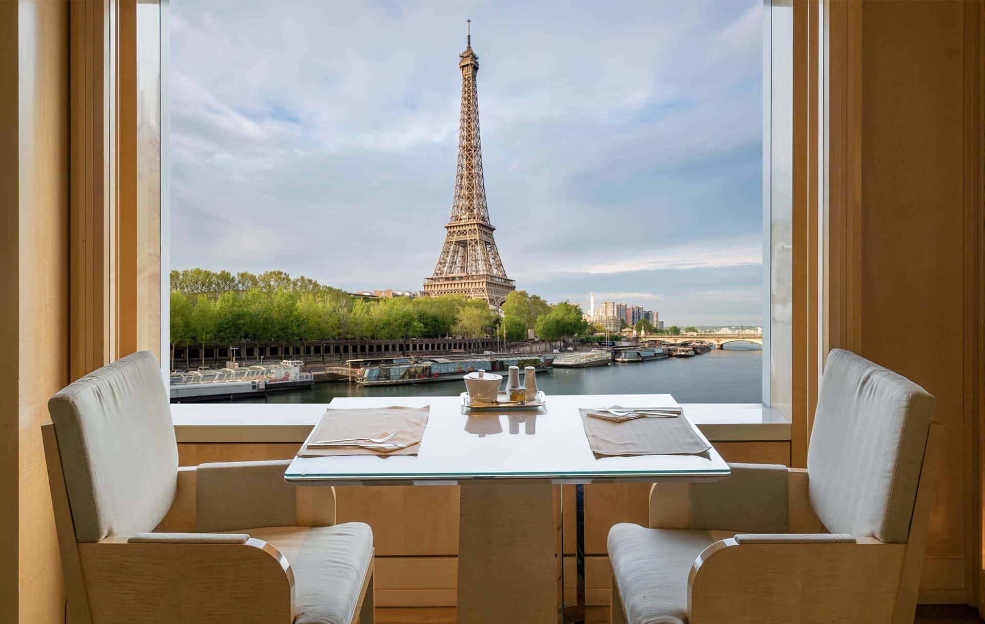 french 桌布 壁紙 — 巴黎飯店房間內，現代二人餐桌套裝，透過大窗戶可俯瞰艾菲爾鐵塔和塞納河。