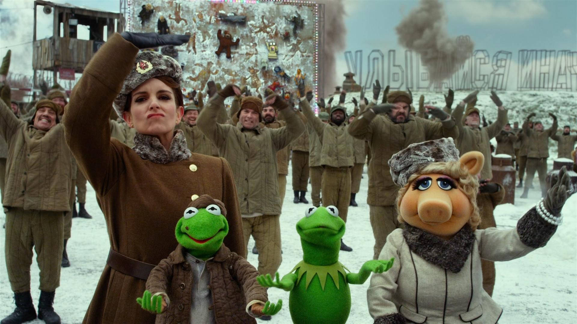 muppets 桌布 壁紙 — 布偶和穿著冬季外套的士兵在雪地裡歡呼，背景充滿節日氣氛。