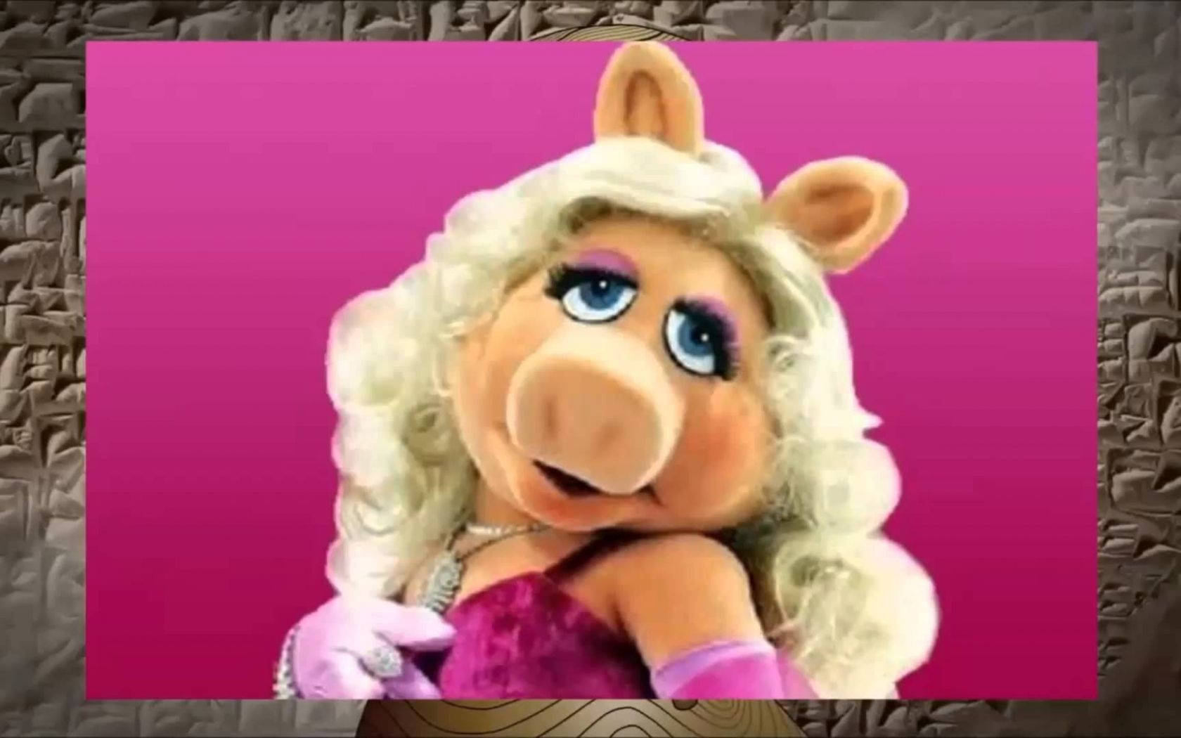 Miss Piggy 桌布 壁紙 — 布偶角色豬小姐（Miss Piggy）擁有一頭金色捲髮和紫色妝容，在充滿活力的粉紅色漸變背景前擺姿勢。