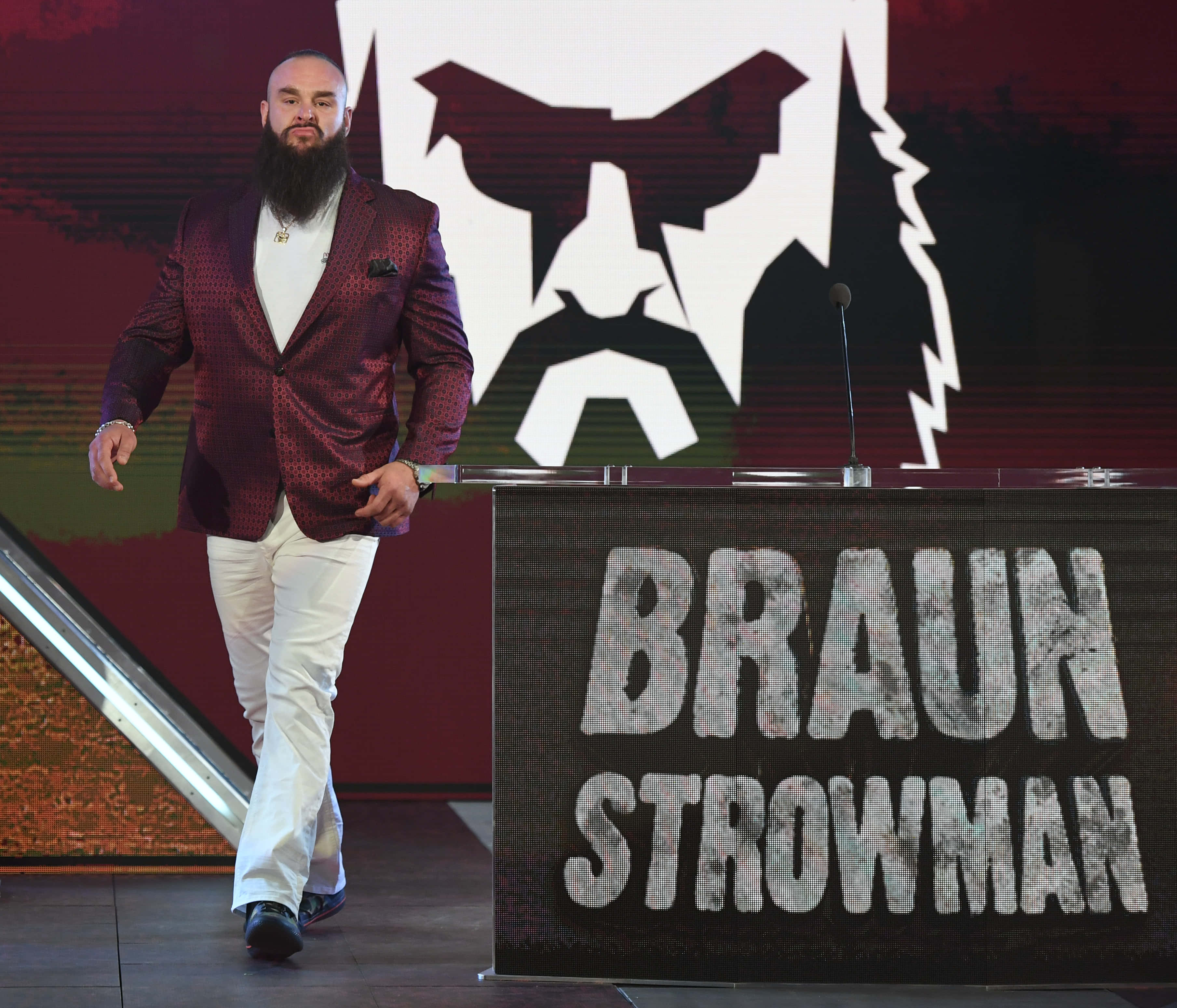 WWE 桌布 壁紙 — 布朗·斯特羅曼自信地穿著栗色西裝外套和白色褲子，走向他在摔角舞台上的品牌講台。